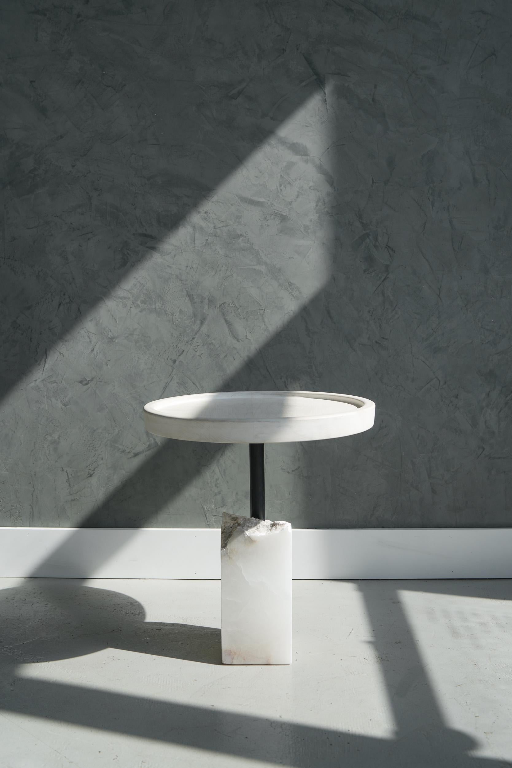 Bleached maple top above a fragmented chunk of alabaster supported by a blackened steel pipe make up this side table.