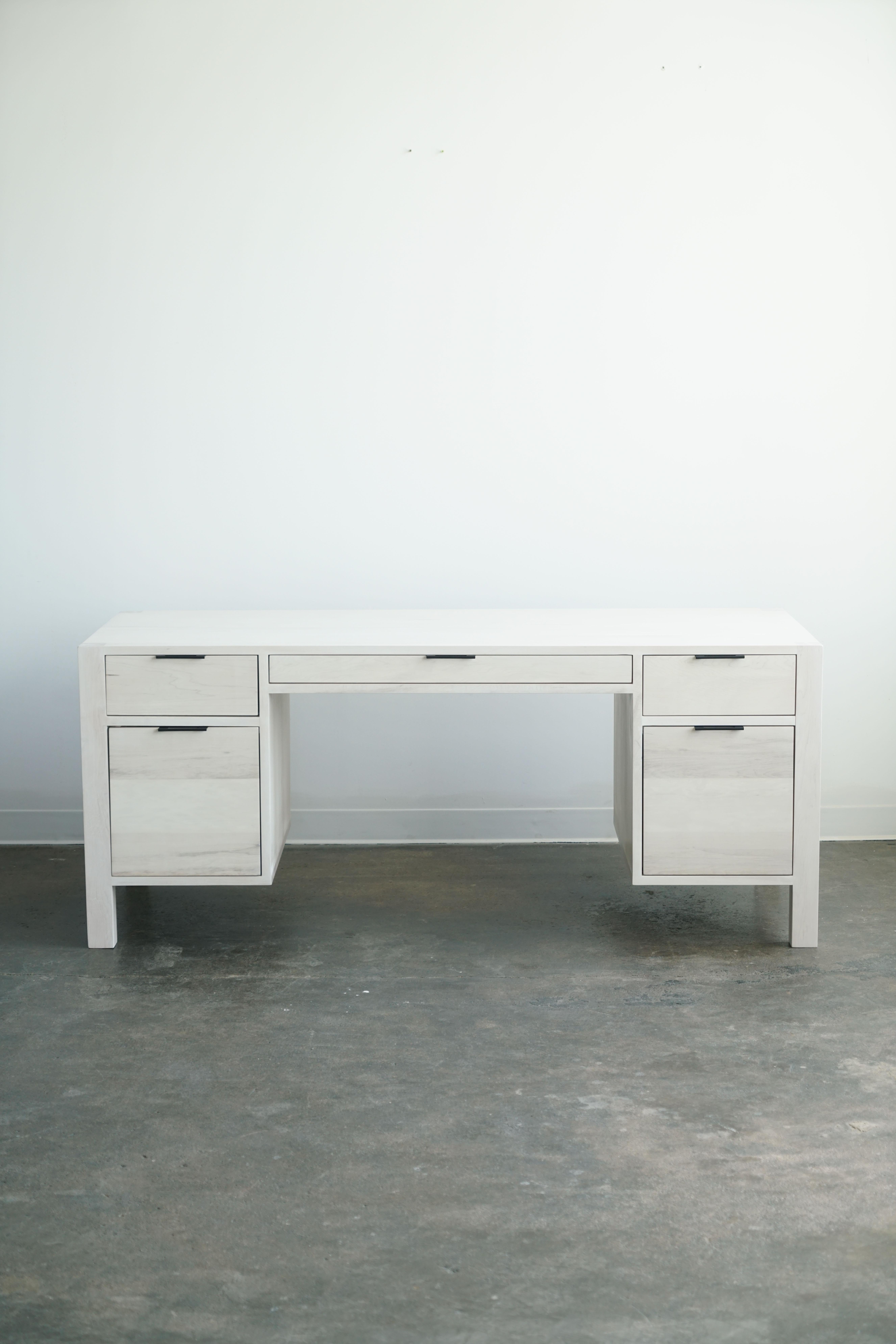 A fresh modern and minimal take on an executive style desk. 

Features five soft-close drawers in three different sizes:
Two file drawers, two standard drawers, and one shallow drawer. 

Made from solid hard maple in a bleached finish. 
by