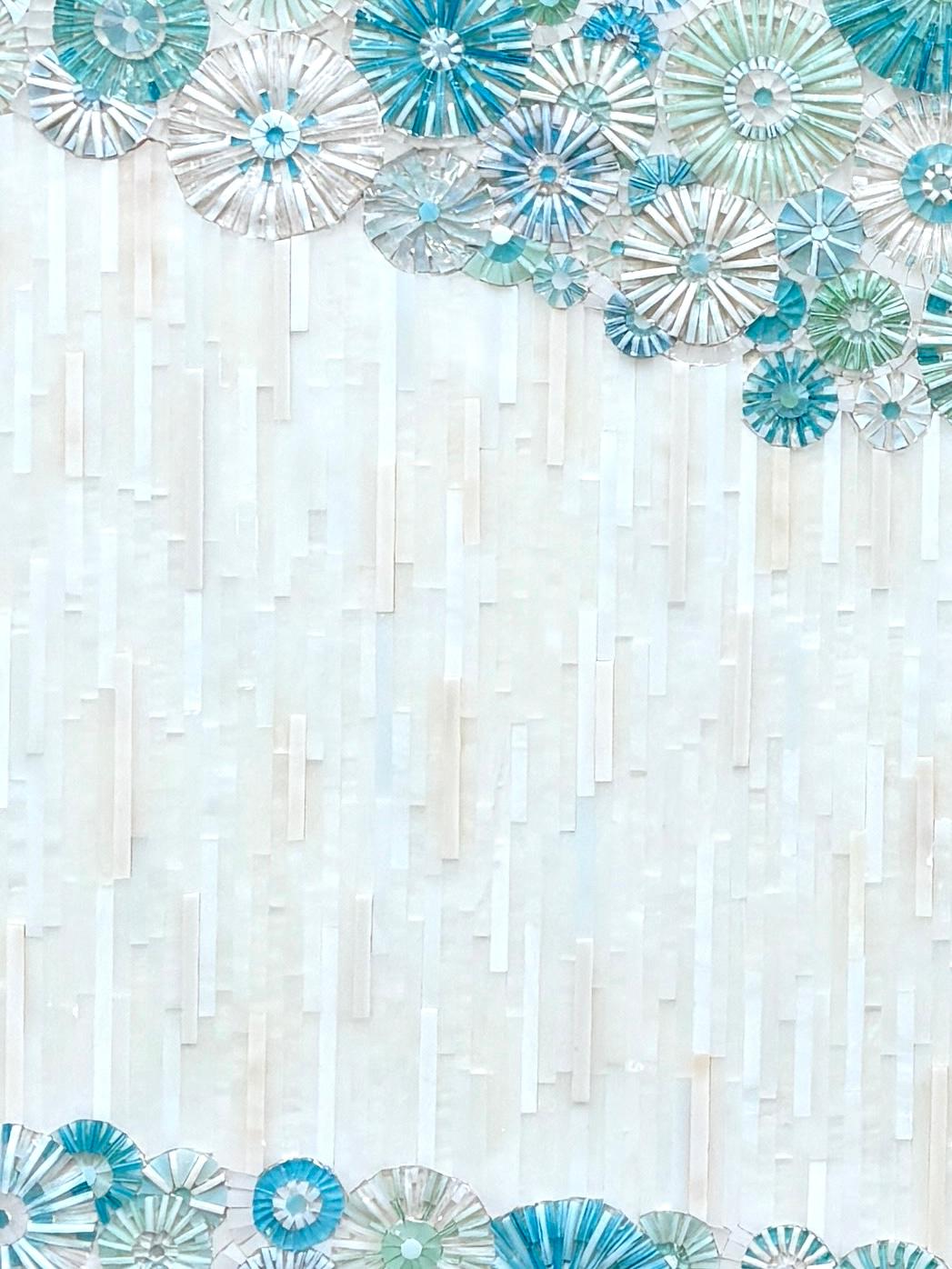 Il mobile da bagno Blossom  di Ercole Home ha un frontale a 2 ante con finitura avorio lavato su Oak. I fiori in mosaico di vetro tagliato a mano in varie tonalità di blu e verde Greene & Greene decorano la superficie, separati da un motivo a