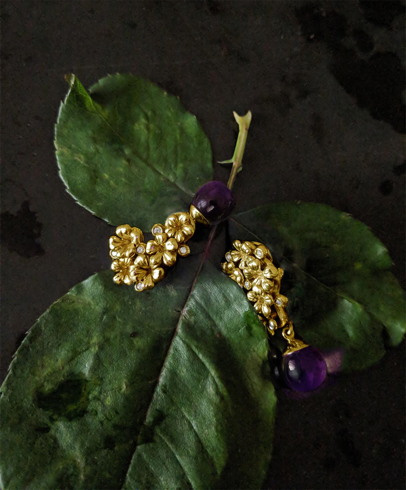 These Plum Blossom floral contemporary earrings by the artist are made of 18 karat yellow gold and are encrusted with 10 round diamonds and amethyst cabochon drops that can be removed and attached. This jewellery collection was reviewed in November