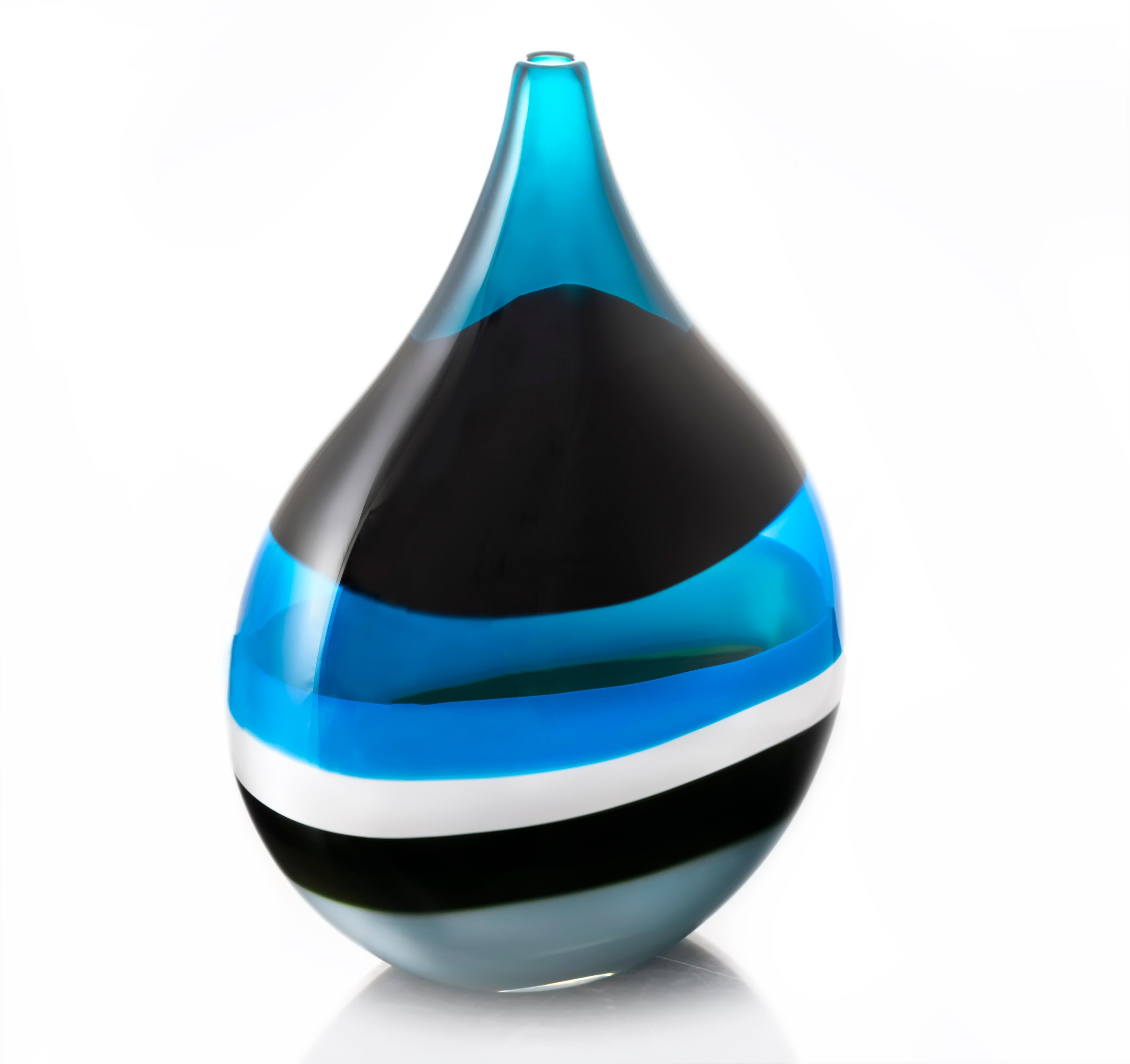 Modern blown glass vase, 6 banded blue flat teardrop by Siemon & Salazar

Inspired by the rich hues and topography of Southern California, alternating layers of opaque and transparent colors are applied to clear glass. New colors are formed by