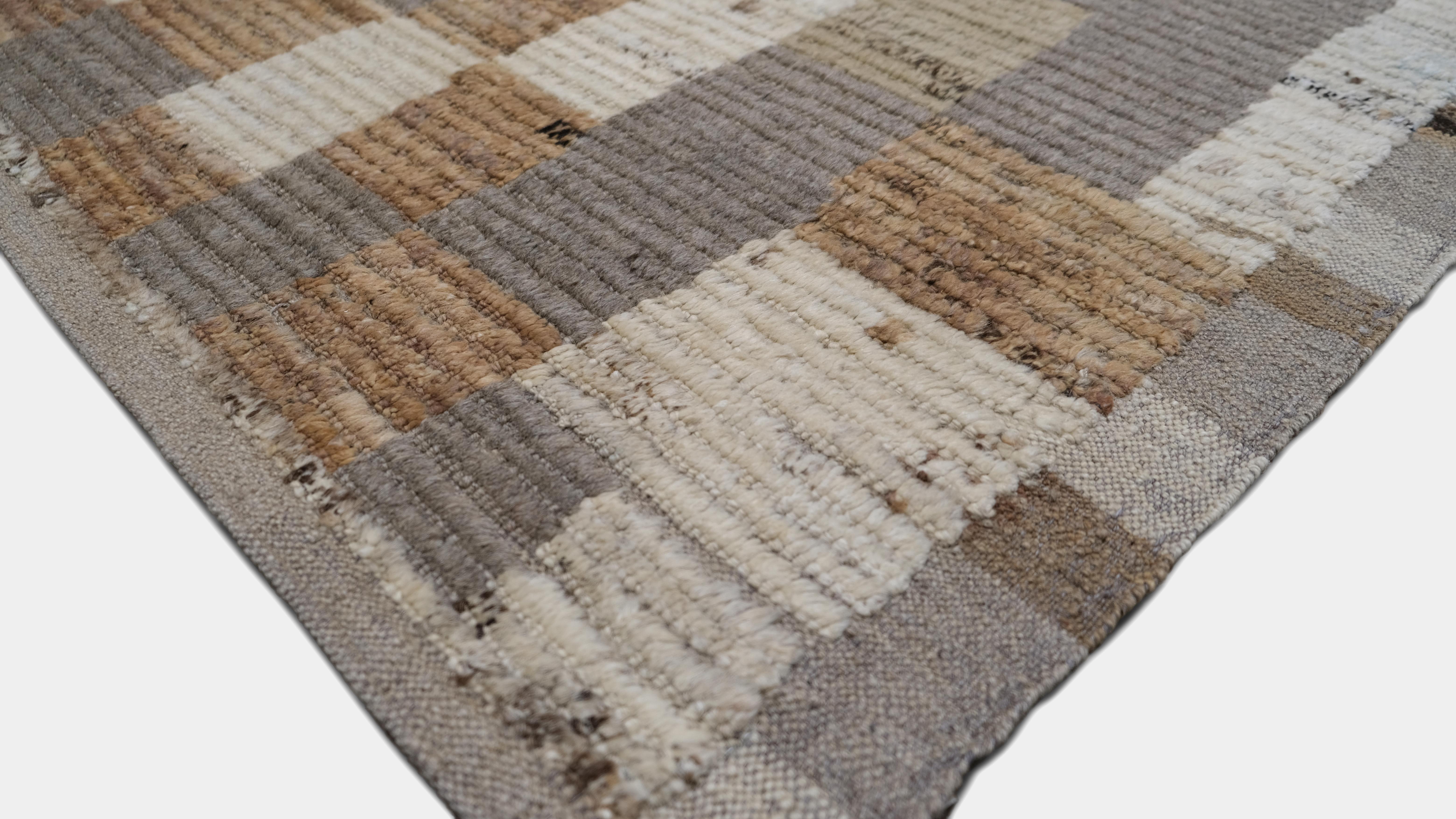 Questo tappeto in lana annodato a mano presenta un disegno geometrico astratto unico, che ricorda un paesaggio urbano moderno o un progetto architettonico. Caratterizzato da beige e blu tenui con accenni di marrone caldo, questo tappeto artistico