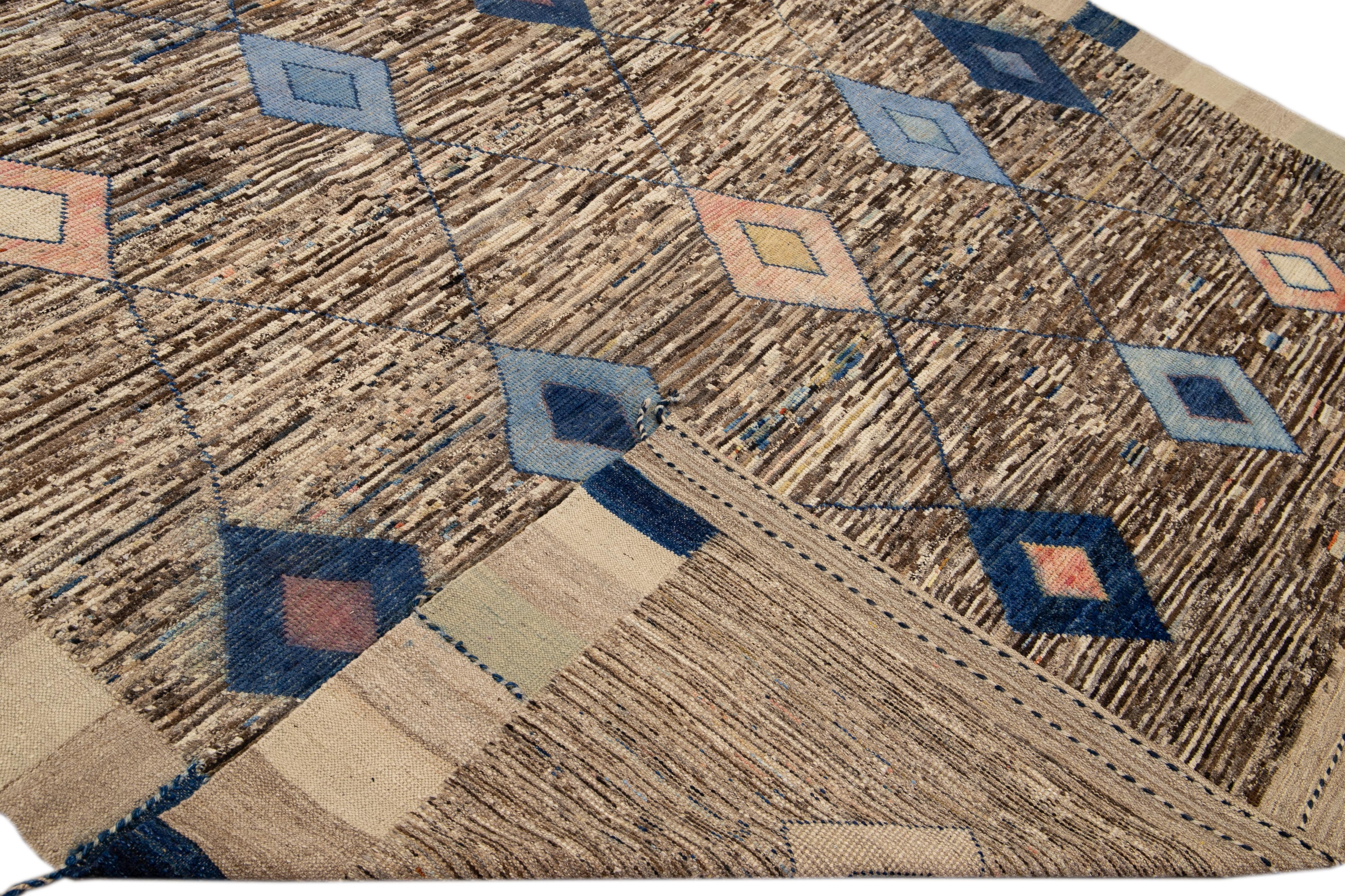 Beautiful Moroccan style handmade wool rug with a brown field. This Modern rug has peach and blue accents and beige-blue braid fringes featuring a gorgeous all-over geometric boho design.

This rug measures: 9'3