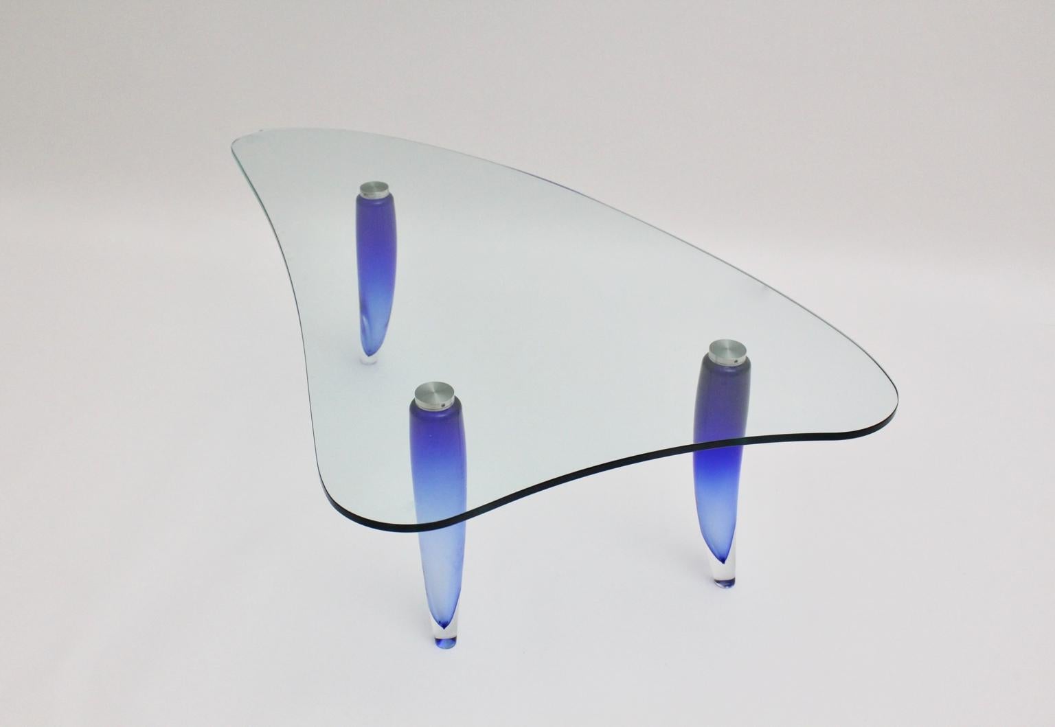 Table basse moderne en verre vintage bleu et transparent, qui présente trois pieds en verre incurvés bleus attribués par Seguso. Les pieds de la table en verre bleu aqua sont reliés par trois vis au plateau en verre clair légèrement incurvé...
La