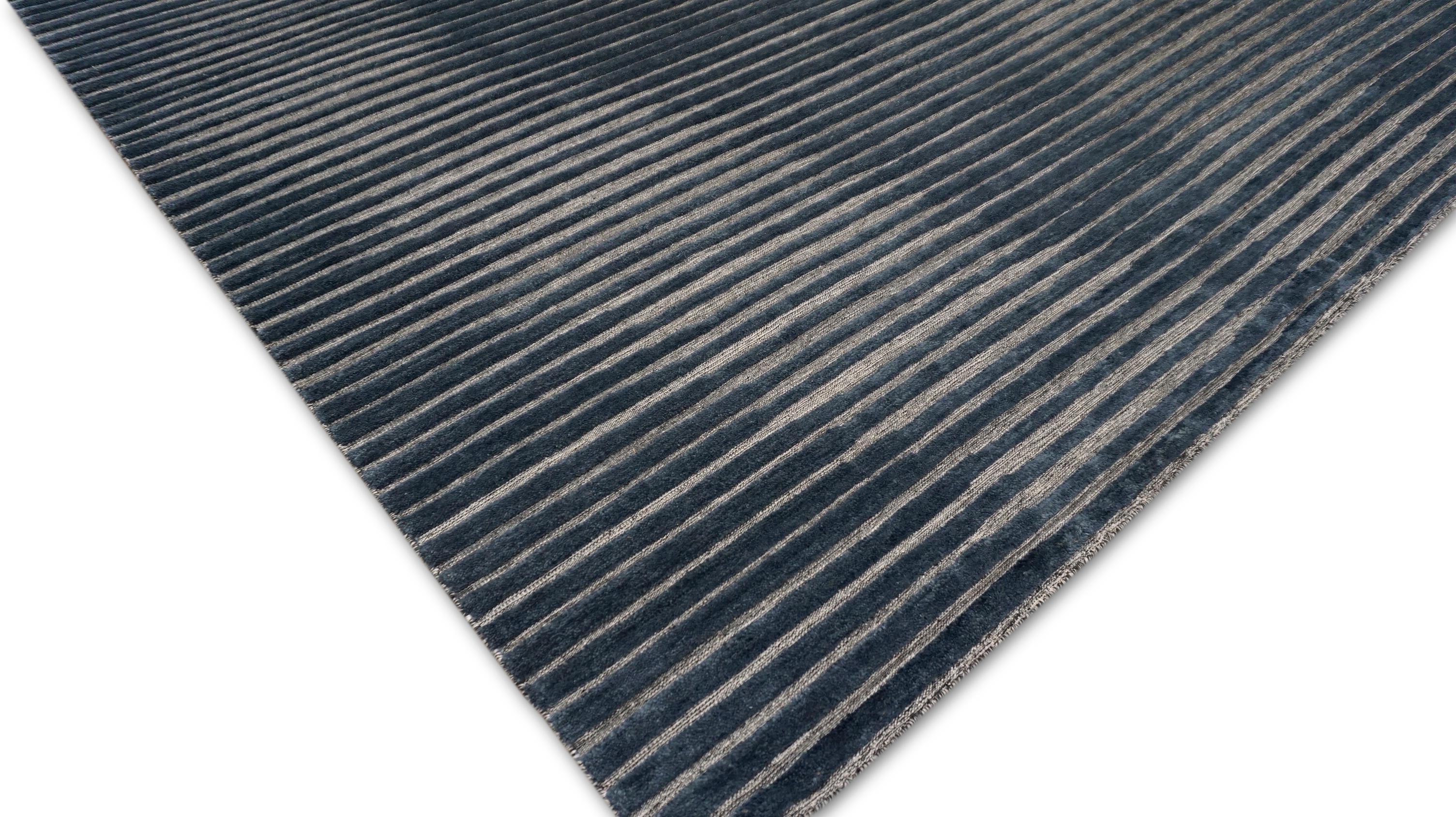 Ce tapis raffiné en laine nouée à la main est une interprétation contemporaine du tapis à motif Ikat, mettant en valeur la beauté de la répétition rythmique et du mouvement tonal. Fabriqué à la main par des artisans qualifiés selon des techniques