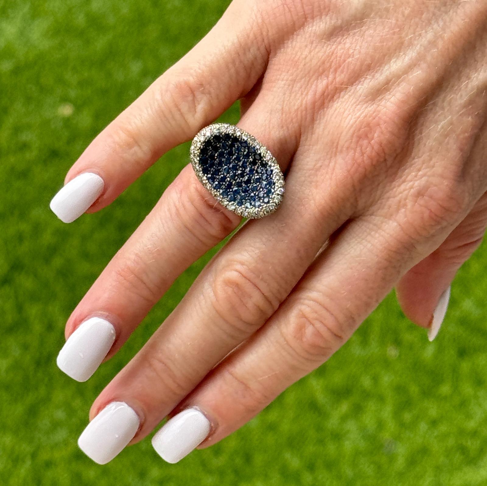 Dieser moderne Sattelring aus 18 Karat Weißgold mit Diamanten und Saphiren besticht durch sein elegantes und auffälliges Design. Der Ring ist mit 171 runden Diamanten im Brillantschliff von insgesamt 3,00 Karat (Farbe H-I, Reinheit VS2-SI1) besetzt