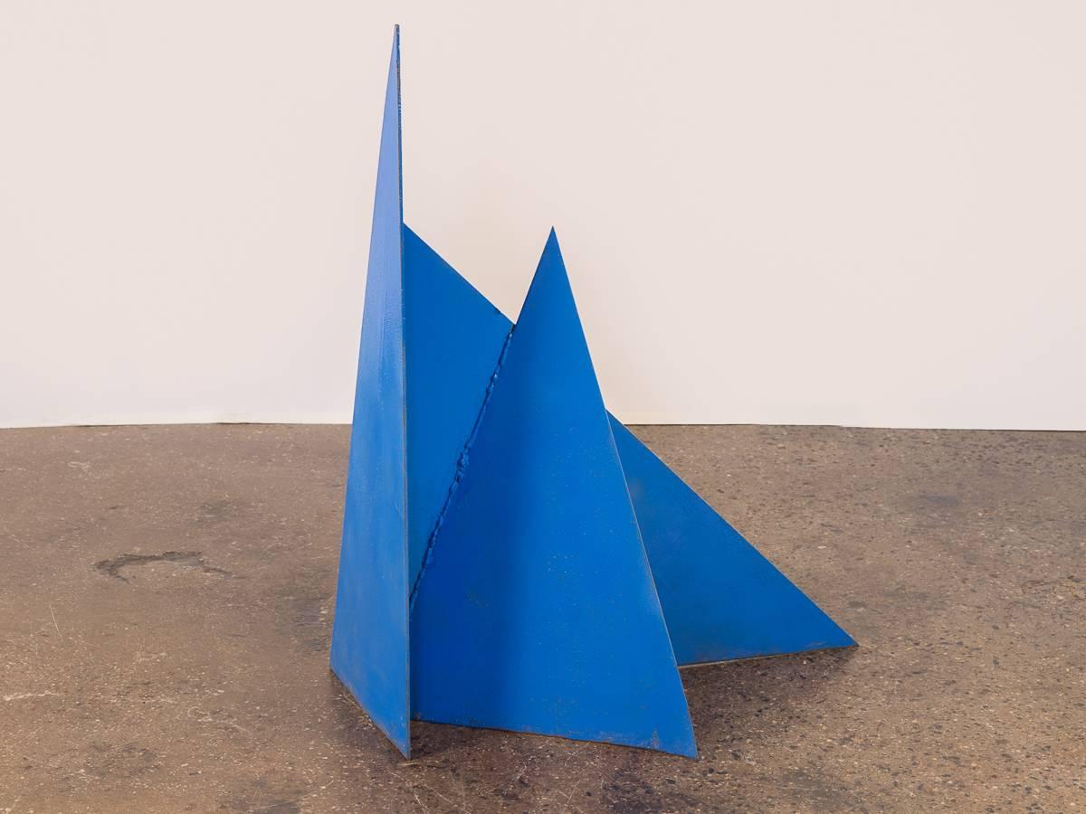 Vivid, abstract steel plate sculpture by John Stritch. The geometric form and azure blue finish plays with the eyes, and whimsically changes at all angles. Solid steel is substantial, but is a manageable scale, quite like a maquette for something