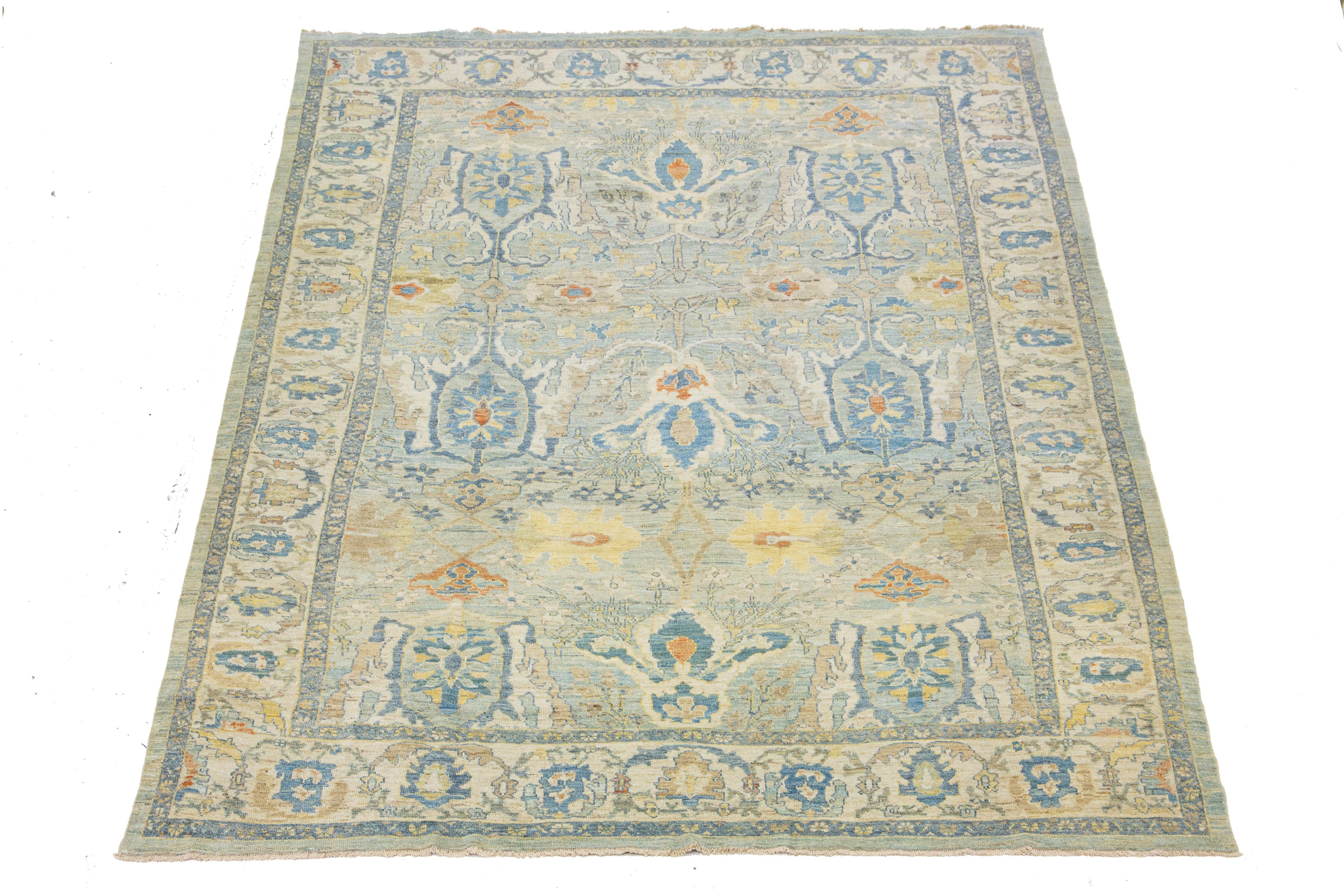 This Sultanabad classic style has been meticulously transformed into a contemporary masterpiece. Crafted with great care, this magnificent wool rug is a blue field. Its frame has a floral motif. To enhance its elegance, it incorporates a design of