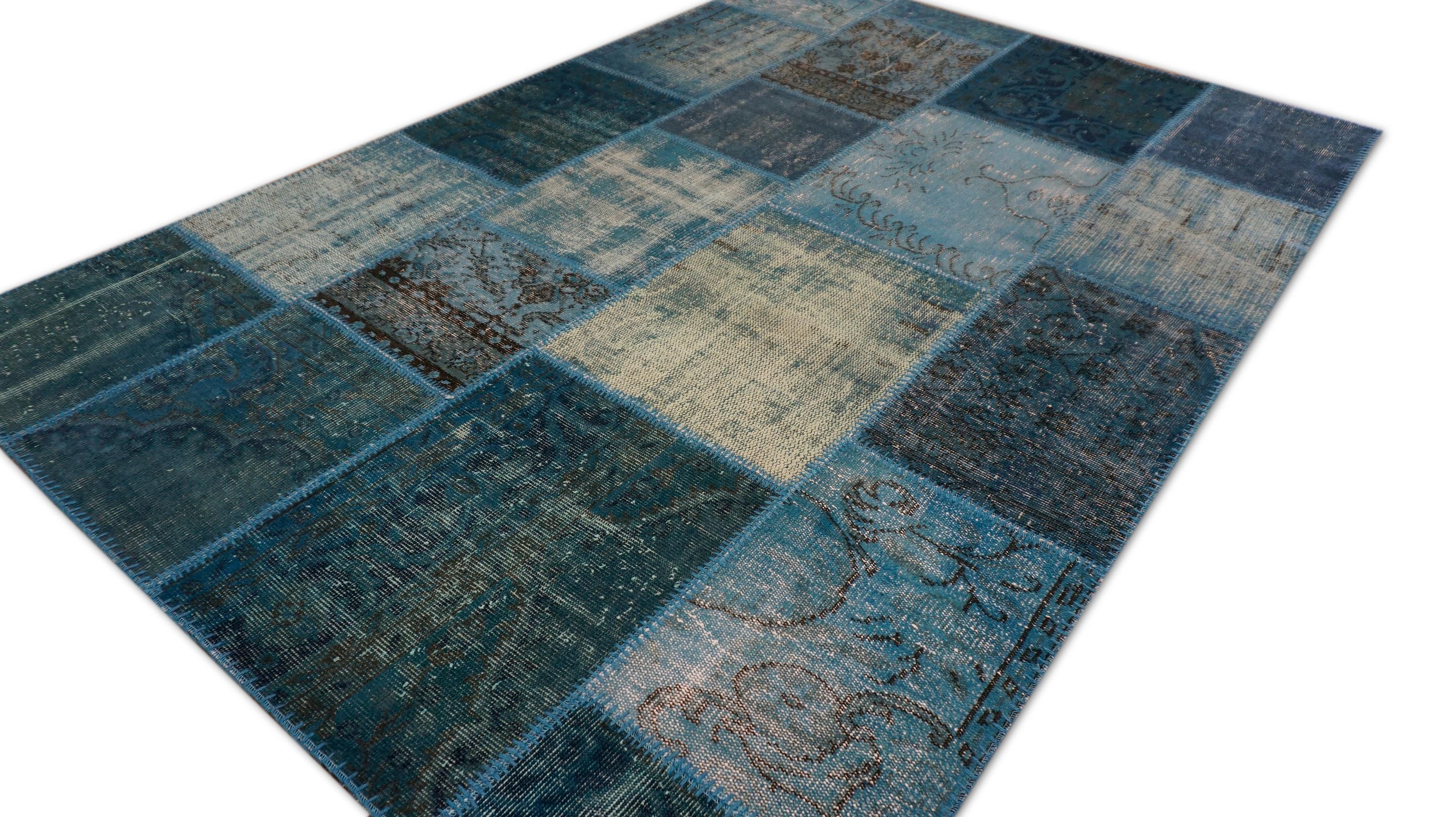 Dieser auffällige Flickenteppich ist ein handgewebtes Mosaik aus alten Teppichfragmenten, die fachmännisch in verschiedenen Blautönen gefärbt wurden - Himmelblau, Denim, Marine, Schiefer und Aqua. Es ist eine einzigartige Kreation, die die Webkunst