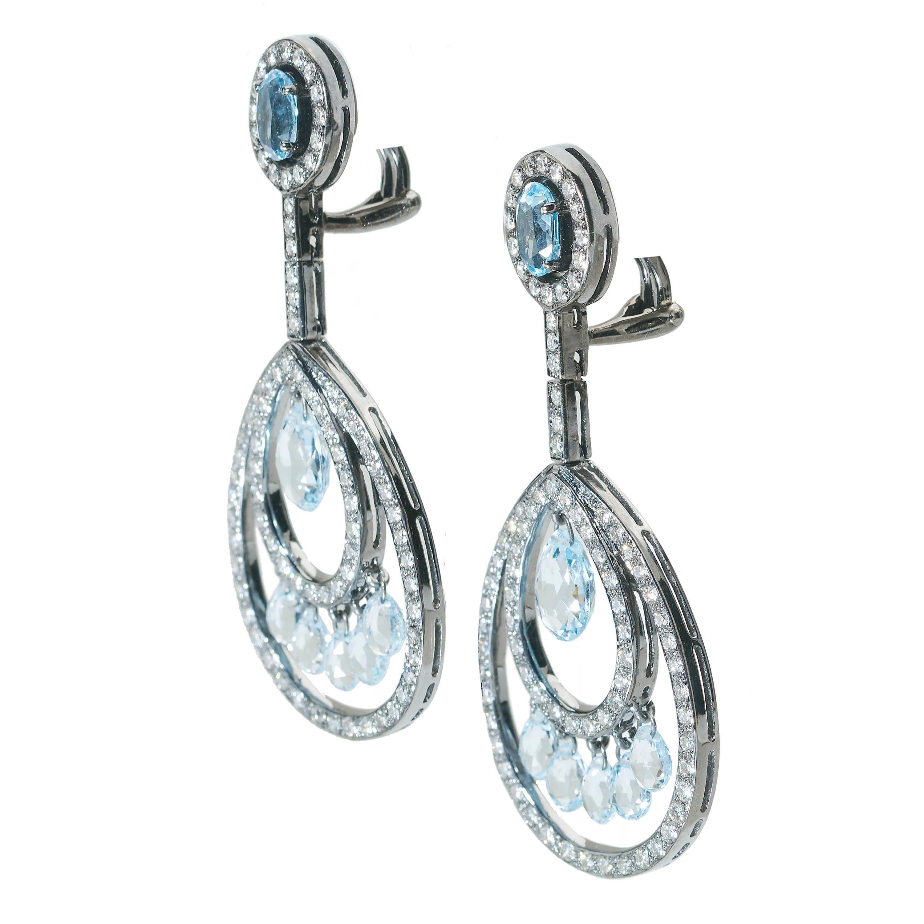 A pair of blue topaz and diamond drop earrings, comprising tops set with an oval faceted pear shape diamond, surrounded by a circle of round brilliant-cut diamonds, with a row of round brilliant-cut diamonds, joining a pendant formed of two open