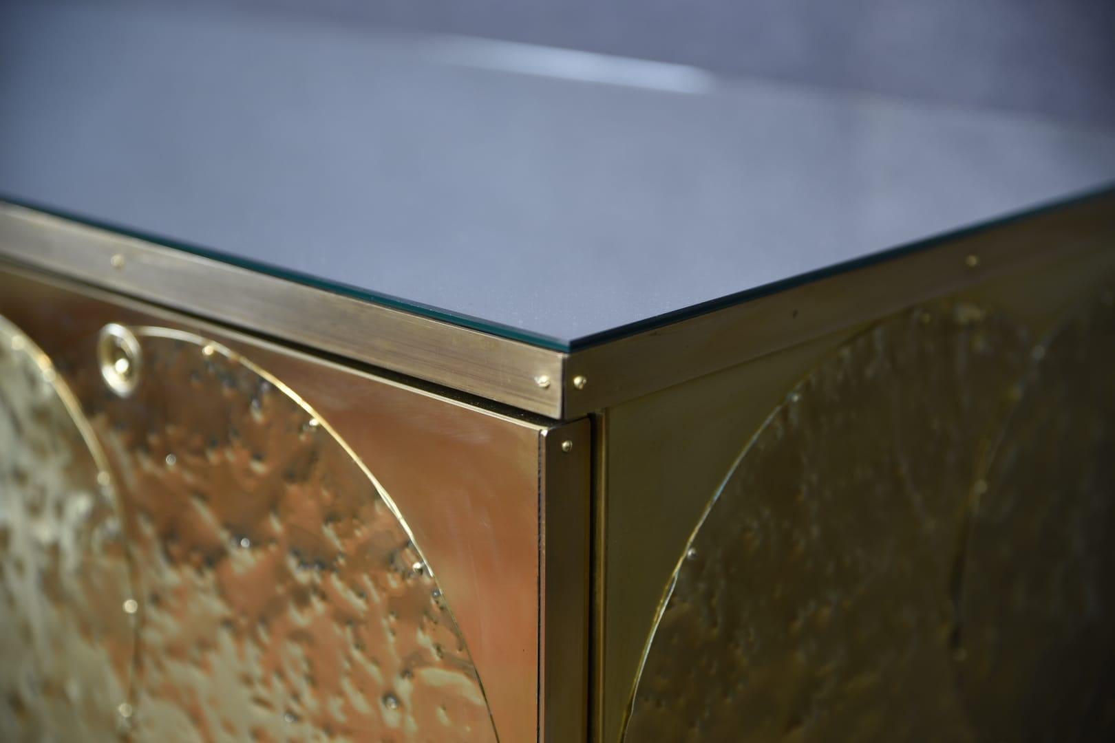 A modern brass and birch sideboard handcrafted in Italy, this beautiful piece features 8 spacious drawers and a refined Mid-Century Modern style.

Crafted from solid birch and finished with engraved and hand-pressed brass, each sideboard is