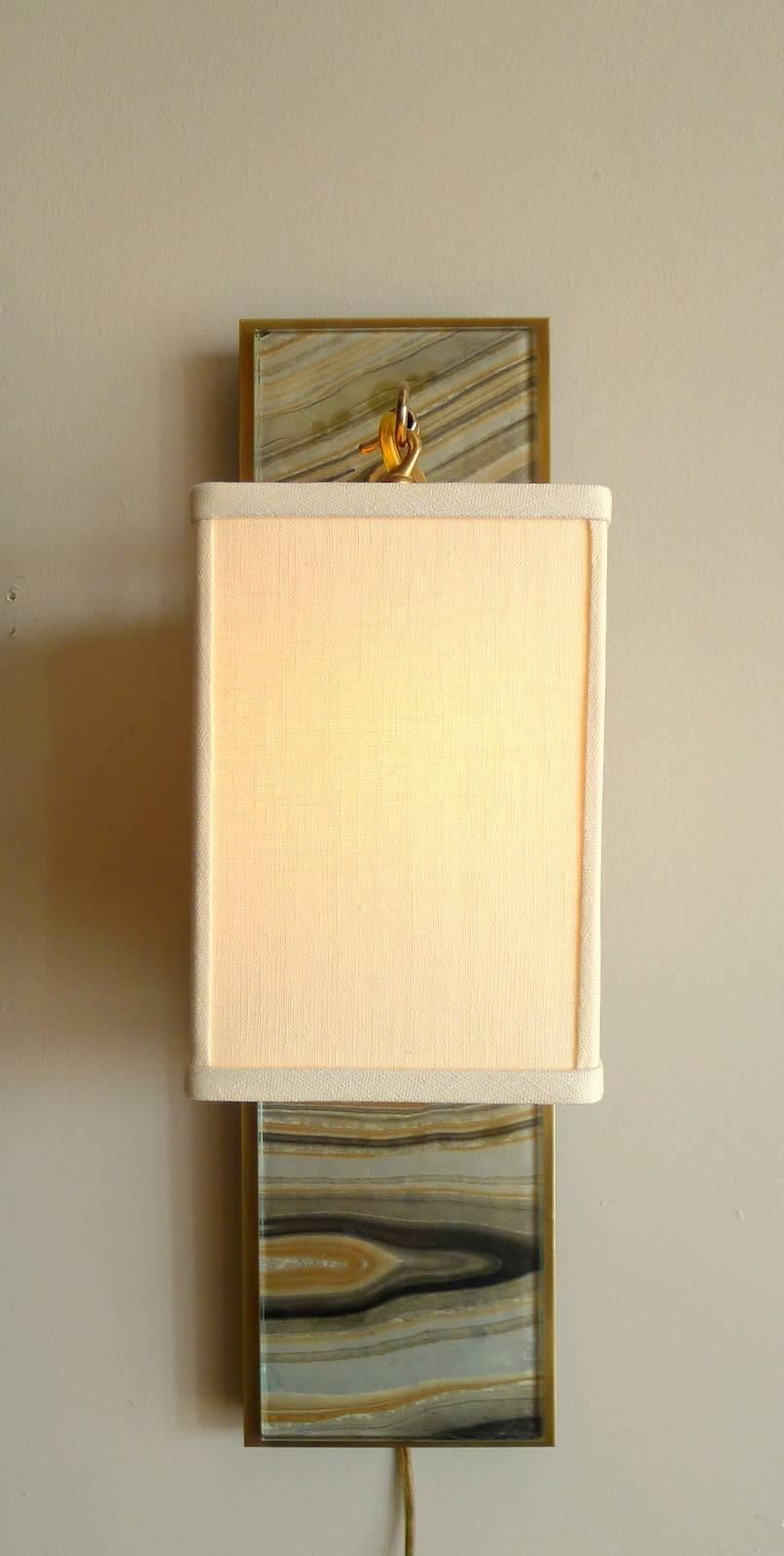 Modern brass and marbleized wall sconce V1 by Paul Marra. Glass over marbleized paper. Brass. Linen shade shown. Projection is 8