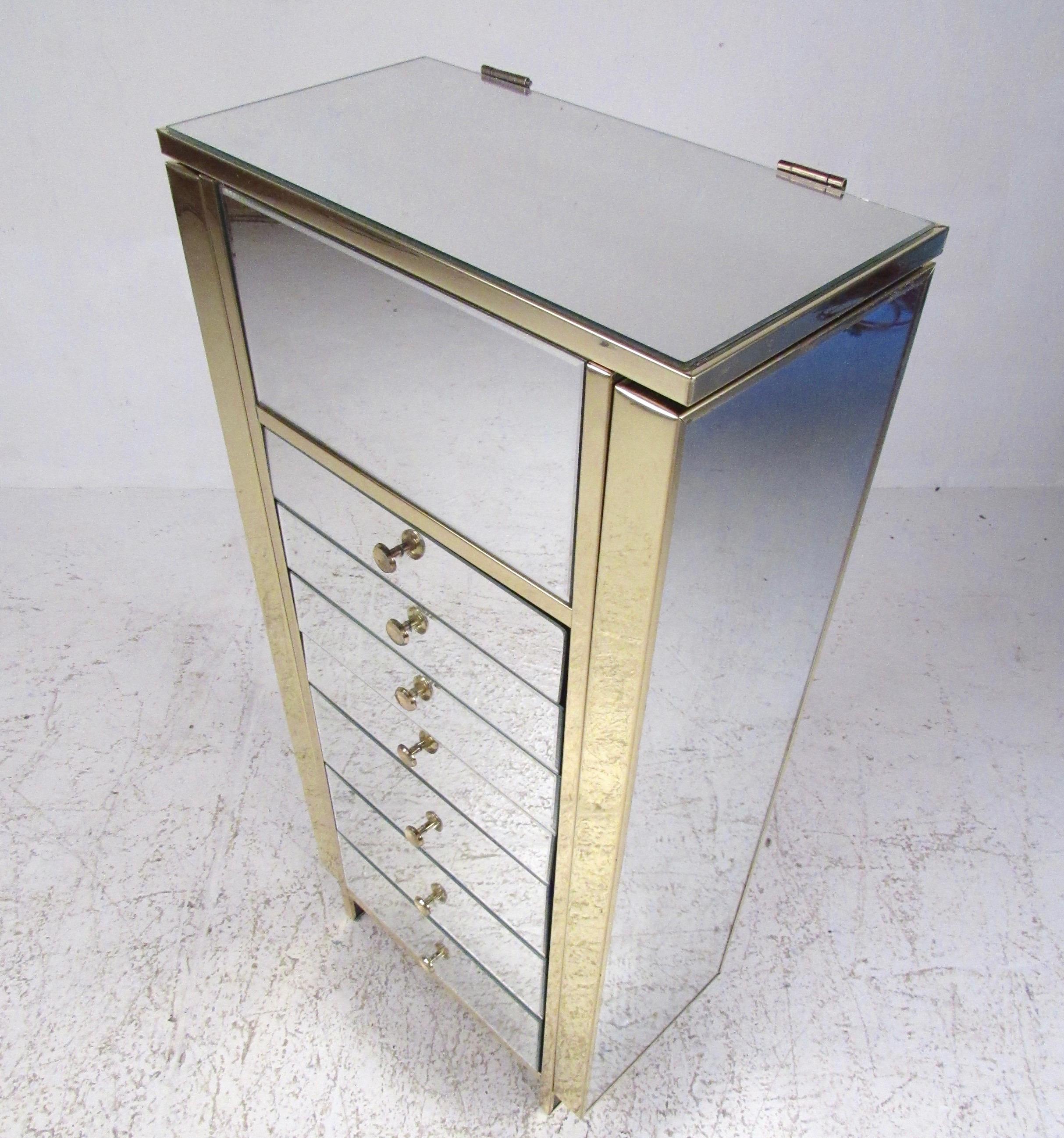 This stylish midcentury style jewelry box features a variety of storage compartments in dresser form, perfect for bedroom or dressing room decor. Mirror and brass finish add elegance to this Hollywood Regency style jewelry chest. Please confirm item