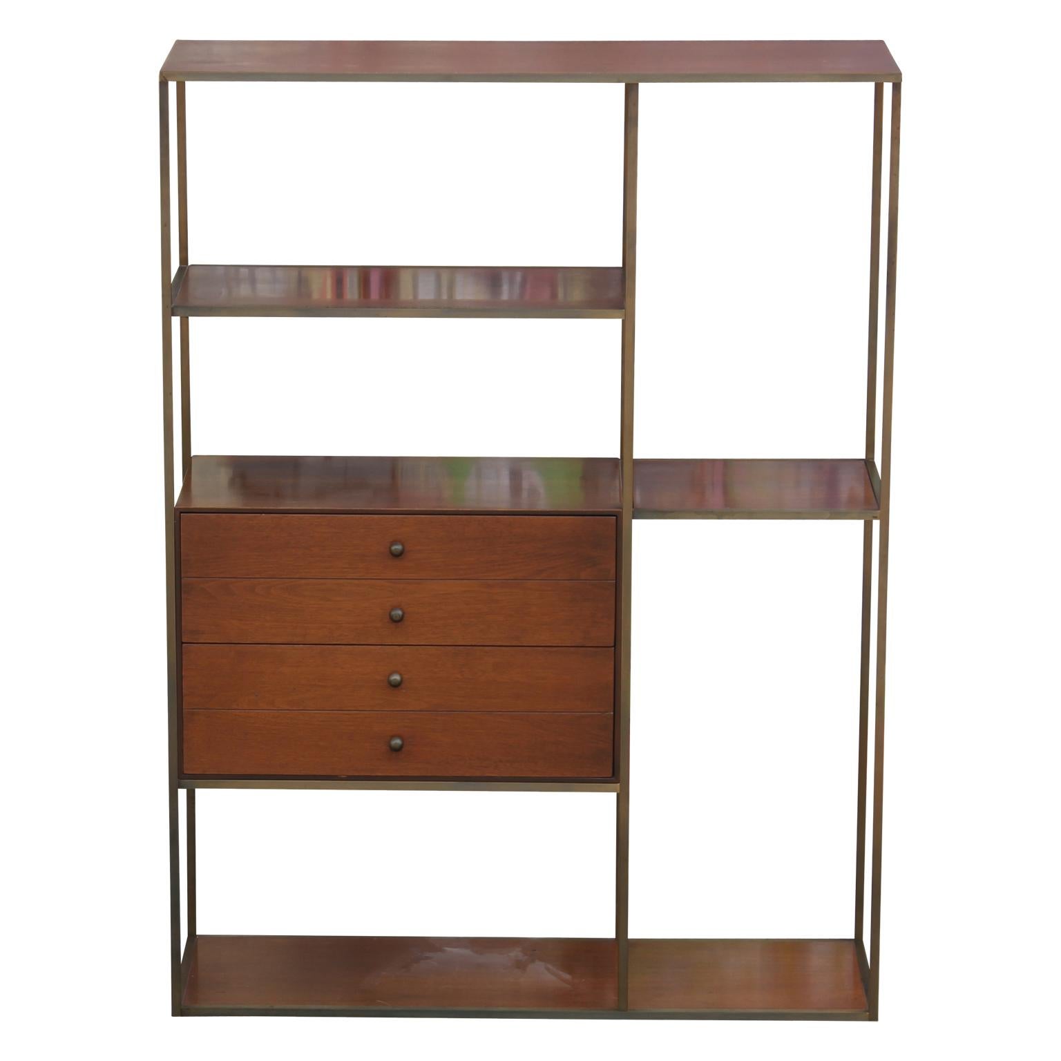 This elegant planner group bookcase is designed by Paul McCobb and is made from a combination of brass and walnut materials. It has multi-level shelves and a set of drawers on the front. Can also be used as a room divider.