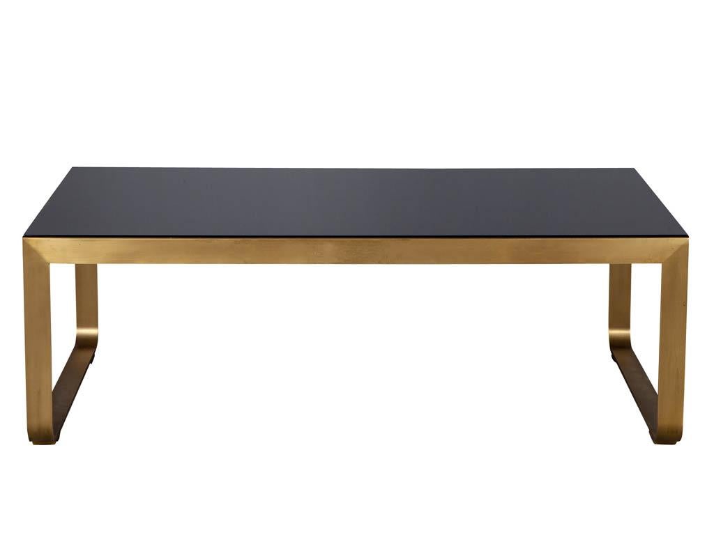 Modern brass cocktail table by Baker Furniture. Featuring sleek brass pedestal and high gloss black wood top.

Price includes complimentary curb side delivery to the continental USA.