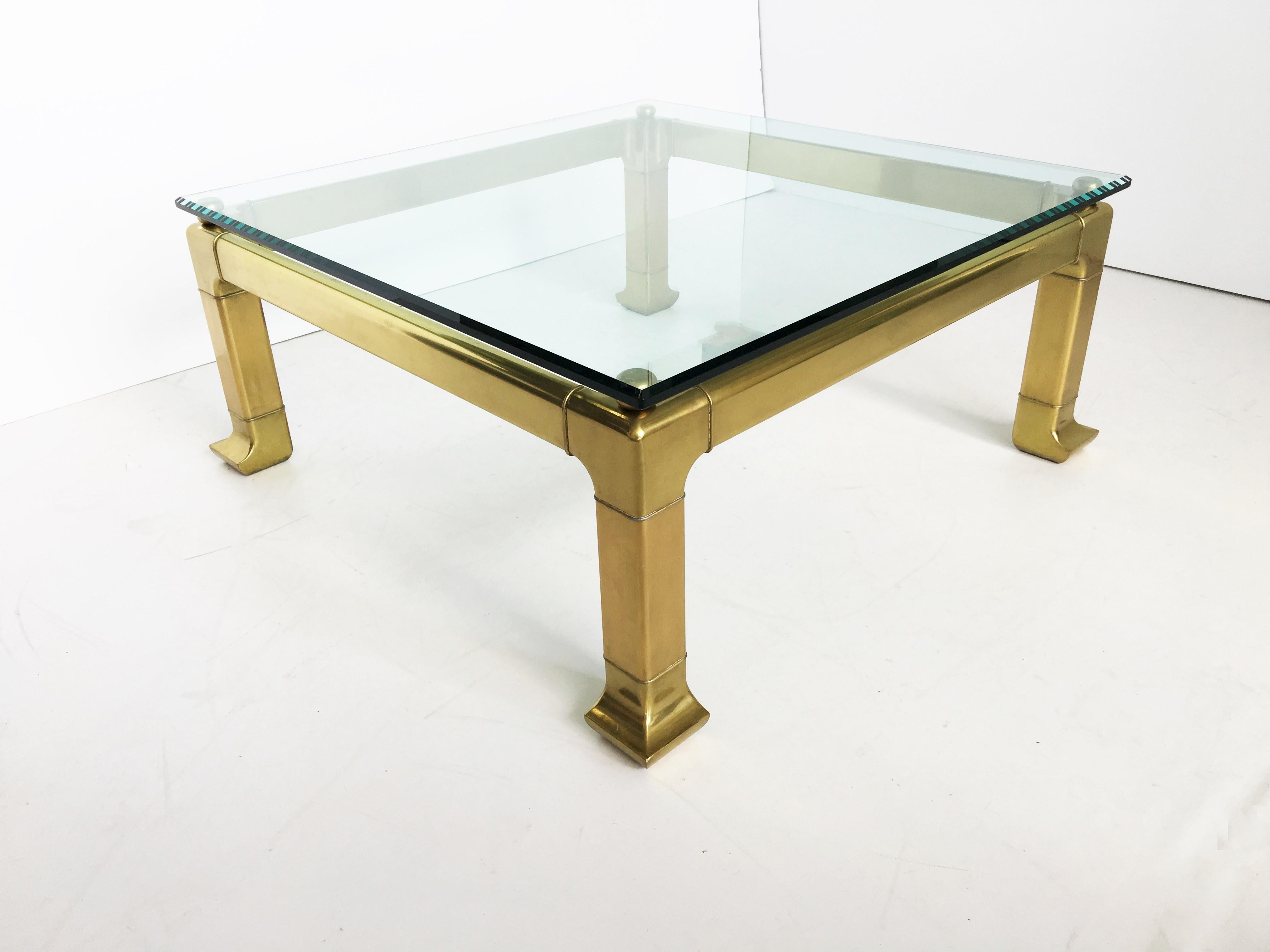Incredible brass coffee table with Asian styling by Mastercraft. Composed of a brass frame and a glass top, this elegant coffee table offers a vintage charm that radiates grace and sophistication. Beautiful patina. Hollywood Regency style.