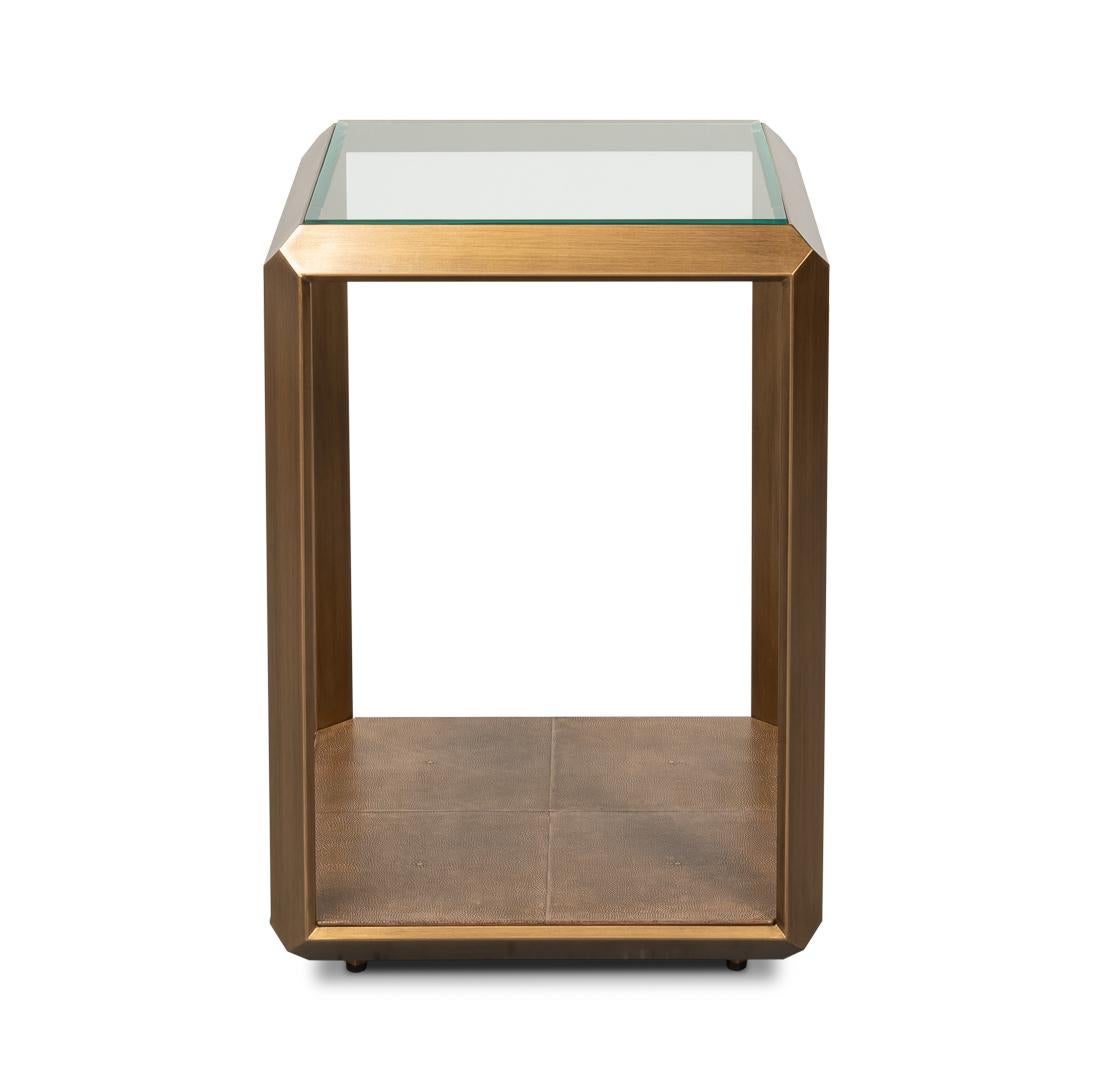 Son design transitionnel épuré est doté d'un cadre en fer à la finition laiton antique, apportant une touche de sophistication à tout intérieur. Le plateau en verre transparent crée une sensation d'ouverture et d'aération tout en offrant une surface