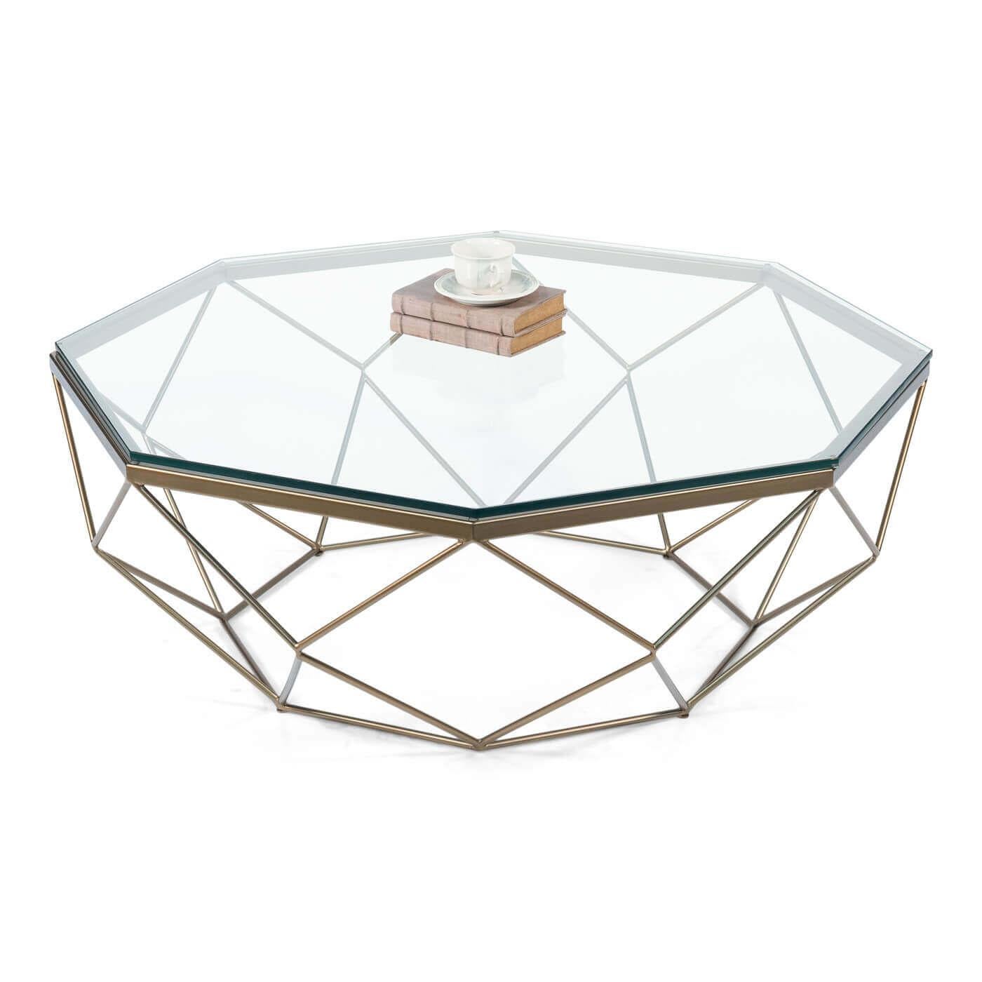 A modern brass octagonal coffee table. This geometric table has a sleek glass top. The octagon base features a design comprised of triangles and squares adding visual interest from all viewing angles. 

The table has a thick .5