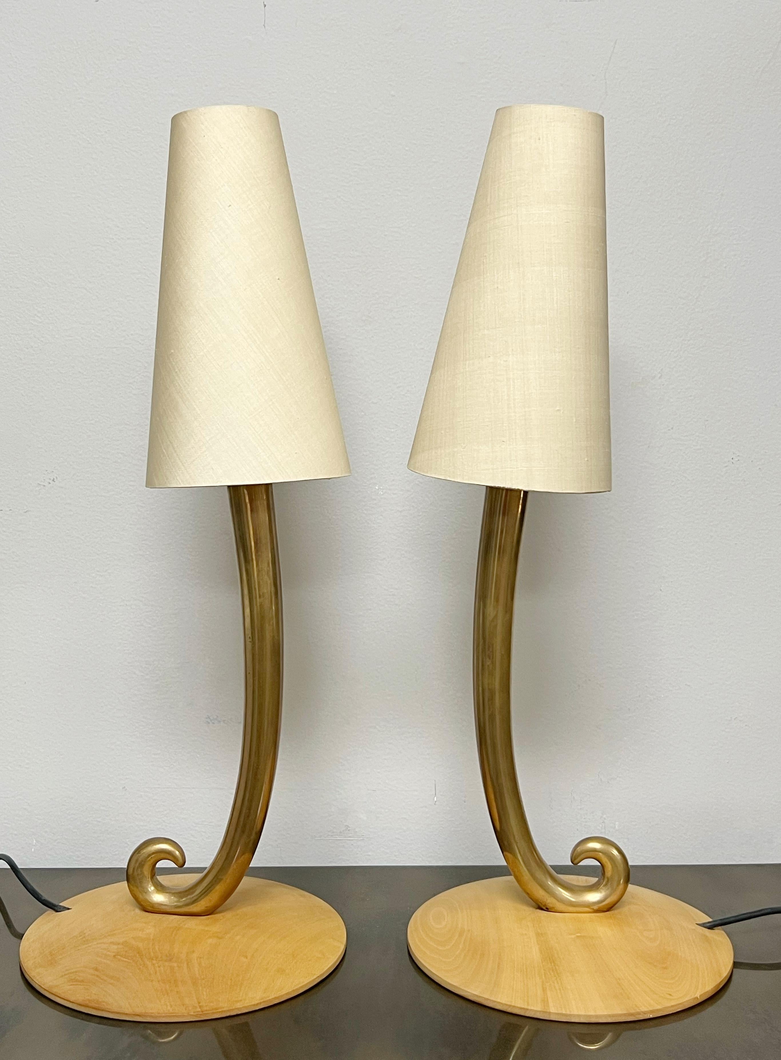 A pair of brass lamps on a wood base. Minimalist organic design. Retain original shades. 