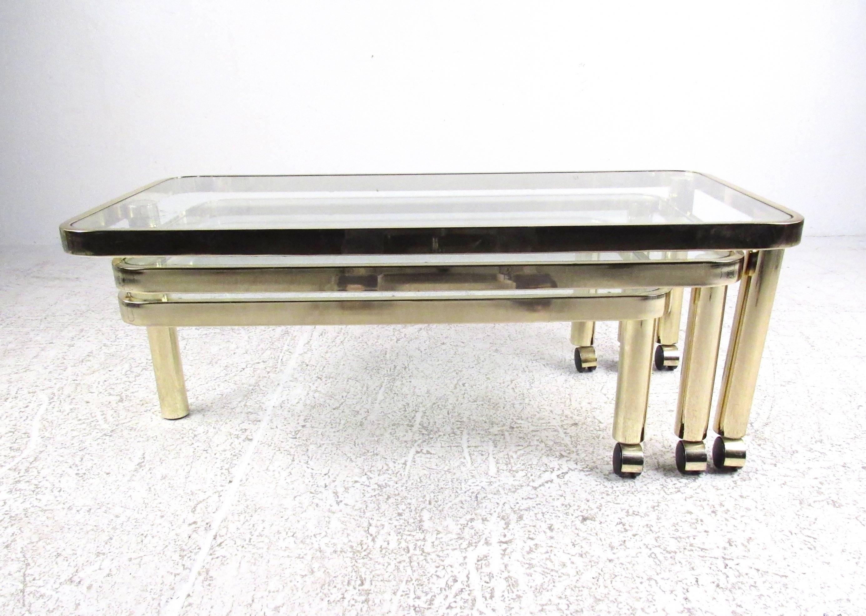 This stylish vintage brass coffee table features three separate table tops ranging in size from 32.5 inches wide to 42 inches, from 12 inches high to 16 inches tall. Design Institute of America created this unique three-tier cocktail table ideal for