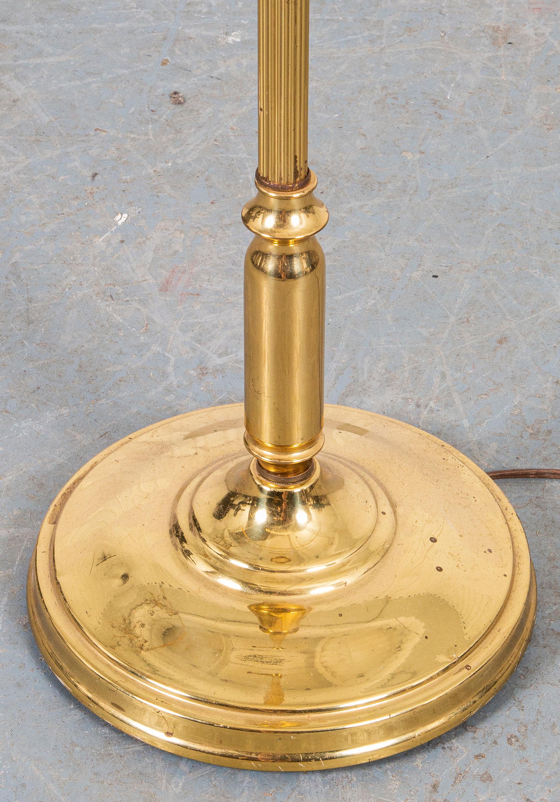 Modern brass torchiere or floor lamp, of typical form with molded circular base. 
Dimensions: 56” height to finial x 11” diameter.