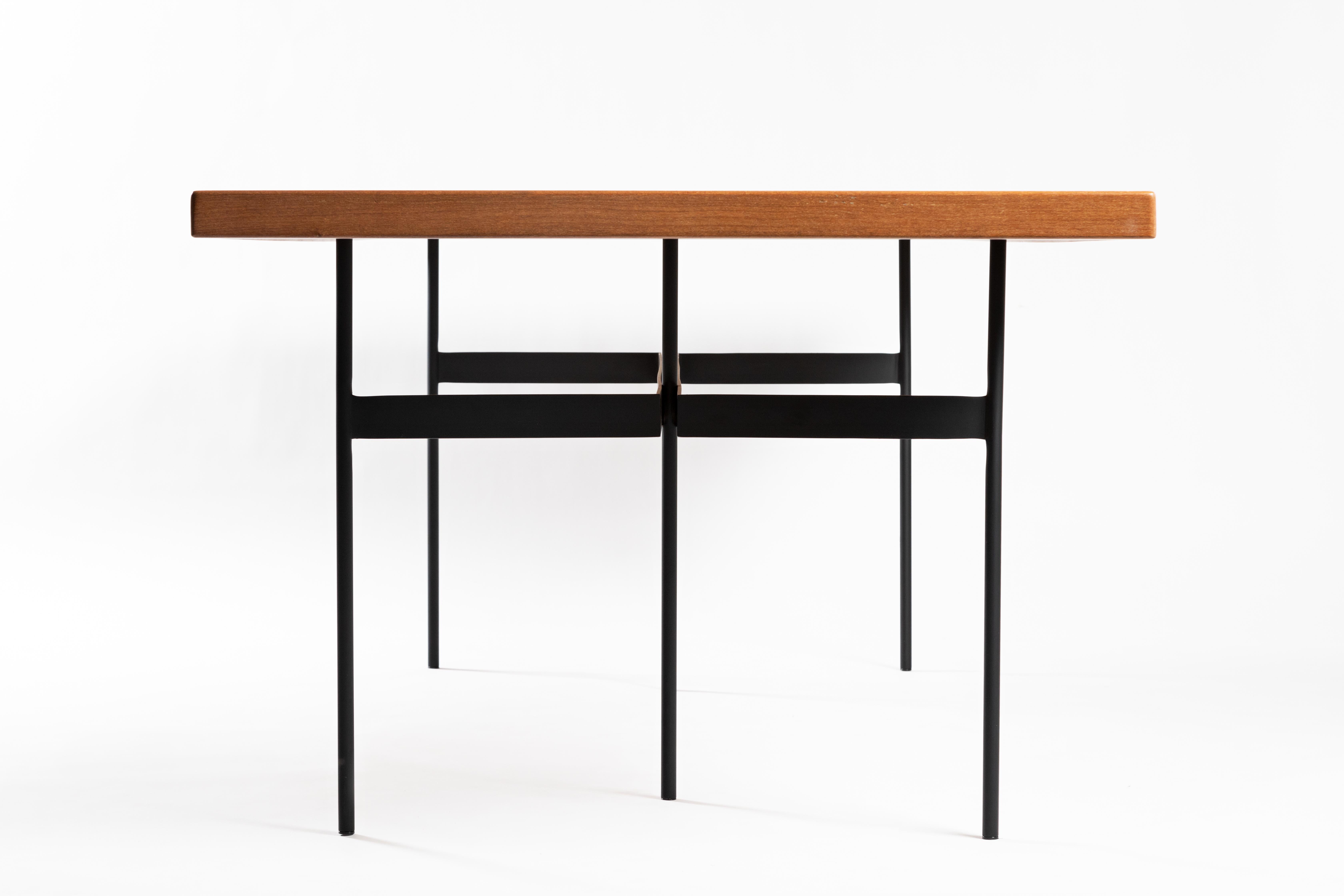 This award winning contemporary Brazilian dining table is made in a minimalist style with solid steel and wood, which lends a simple and powerful design. The table has an architectonic and geometric reasoning, rectangular bars are welded to the
