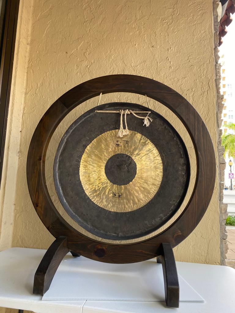This modern Gong has a wooden base having cord holding it in place A wonderful sound adds to the 
ambience of the surroundings