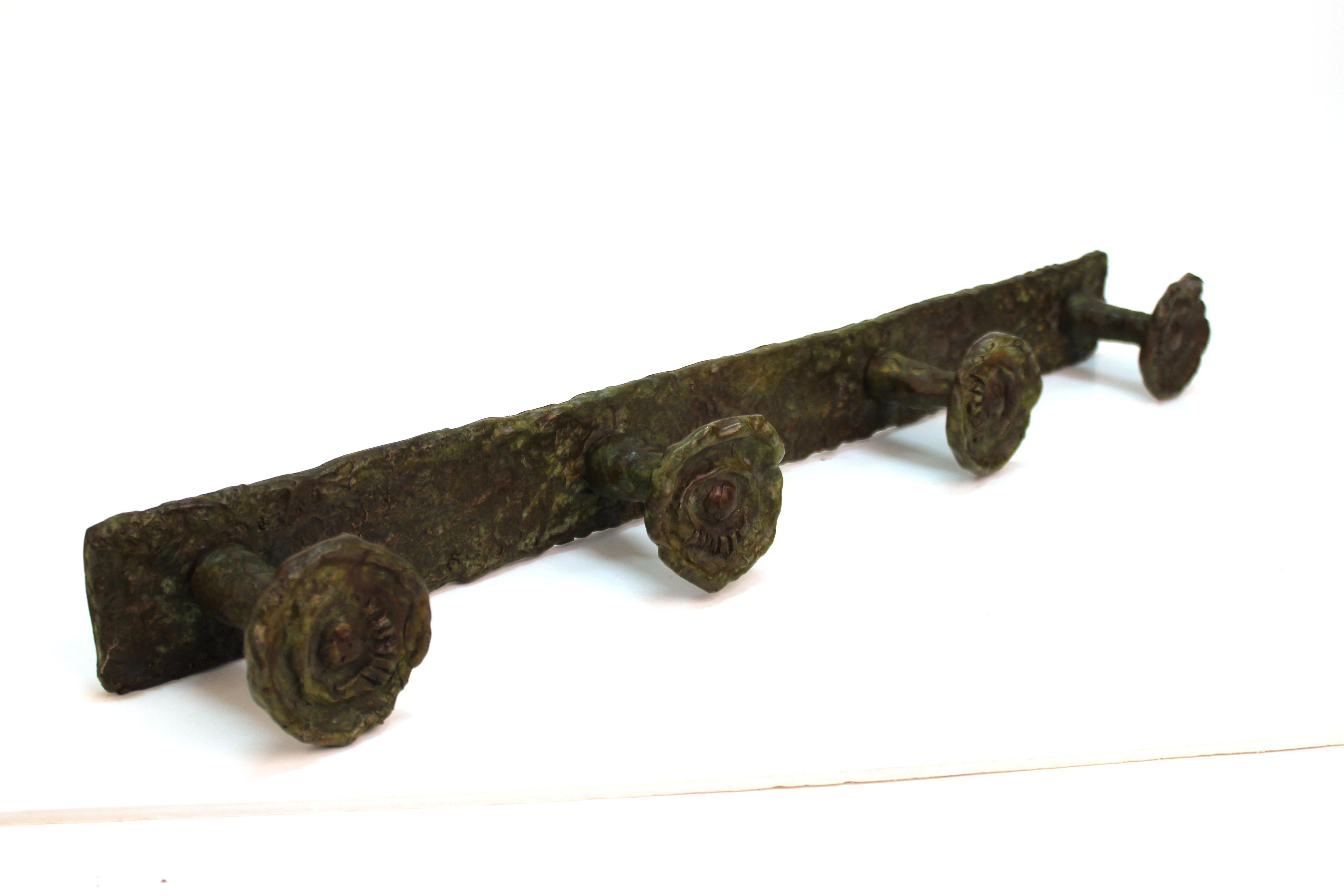 Modern wall coat hanger in bronze in the style of Diego Giacometti, with four hanging knobs with sculpted eyes. The piece was made in the 20th century and is in great vintage condition.
