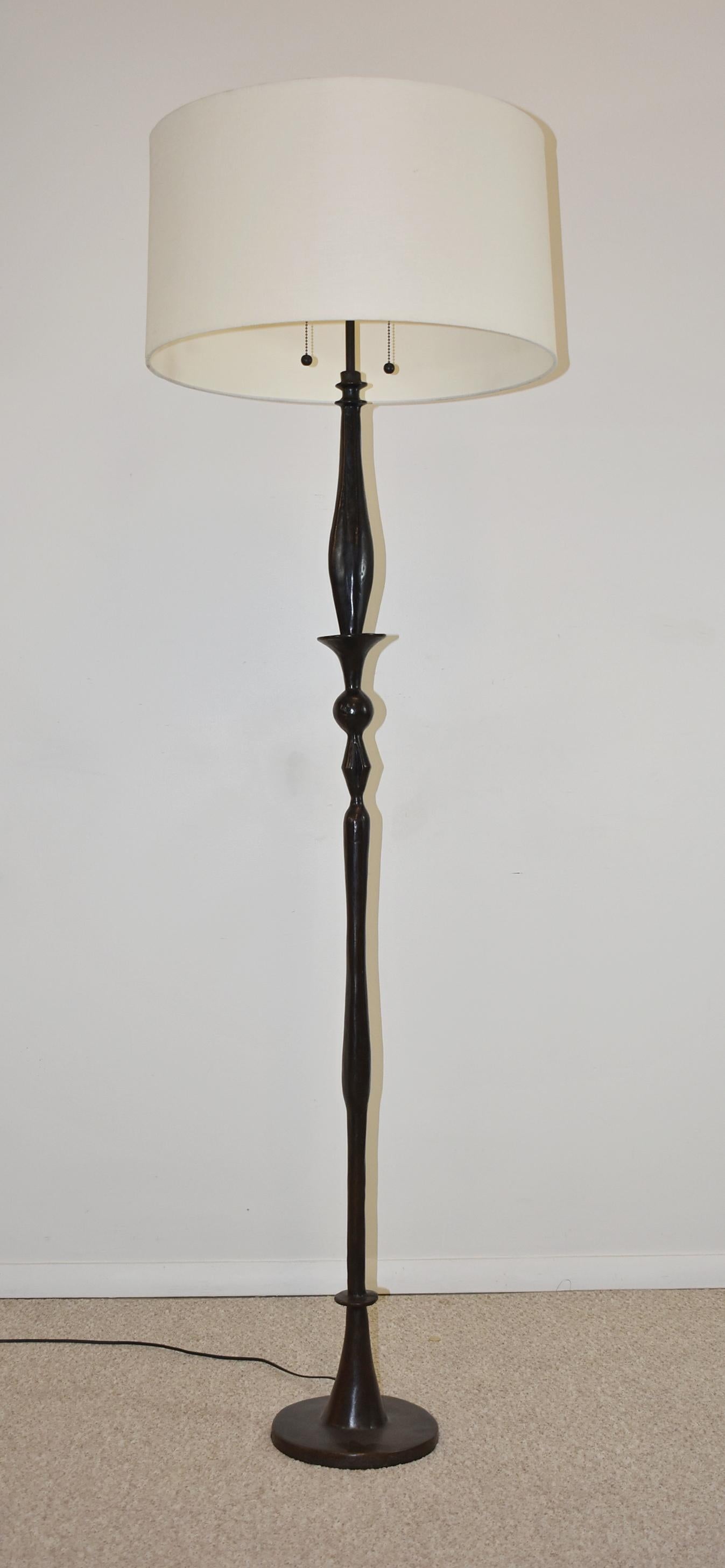 Modern bronze floor lamp in the style of Giacometti. Circa 1980s. This modern designed floor lamp has a beautiful dark patina, two sockets with ball pulls and an adjustable height tube between 71 1/2