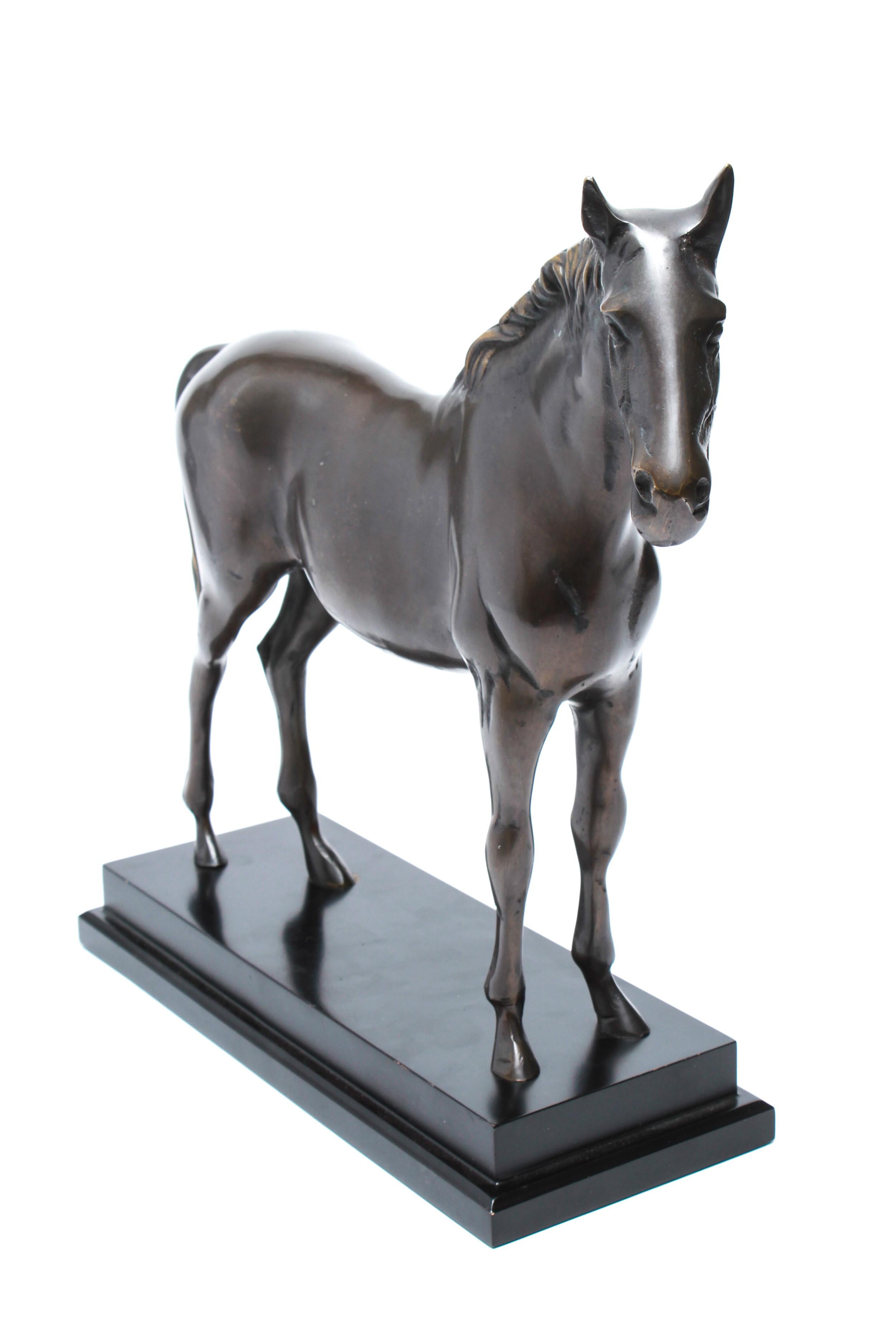 Modern hollow-cast bronze sculpture depicting a standing horse atop a black plinth base. The piece is in good vintage condition with age-appropriate wear.