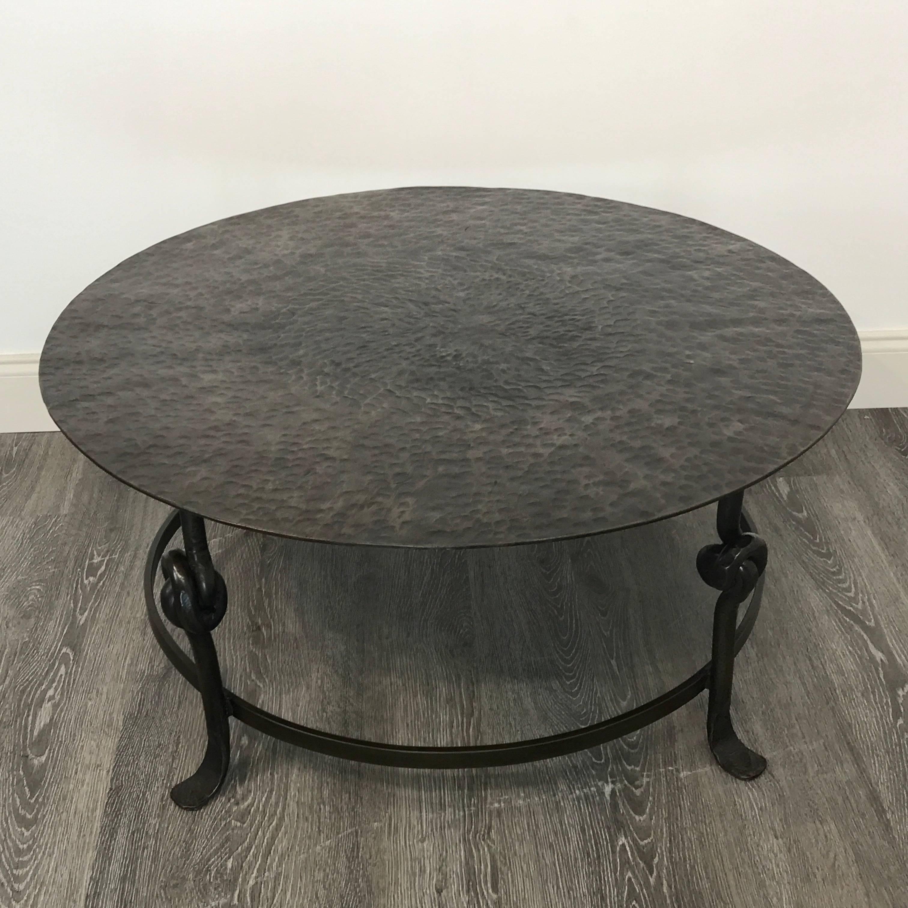 Solid bronze sculptural round coffee table, raised on three knotted legs.