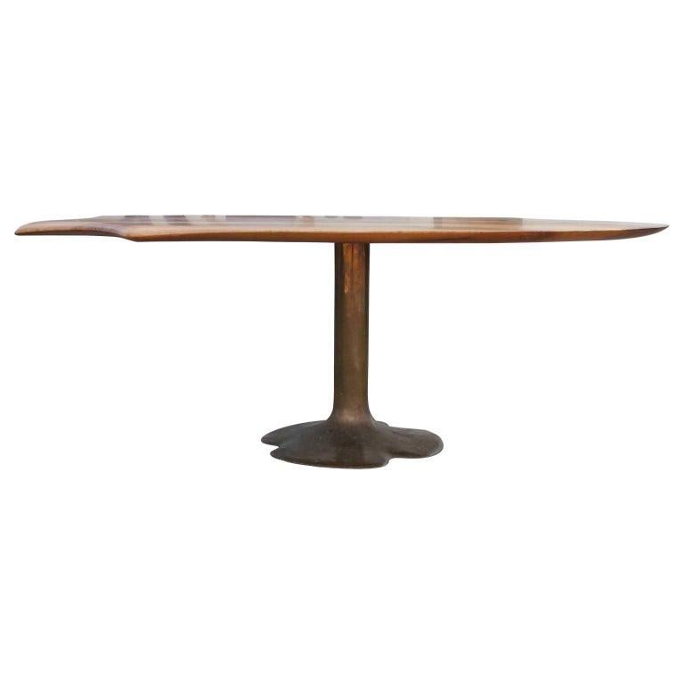 Stunning modern bronze sculptural dining table in walnut. It is made by Oskar Kogoj, and the table has aesthetic sculptural detailing on one end. The table leg is made of bronze and is signed by the designer. His signature also appears on the