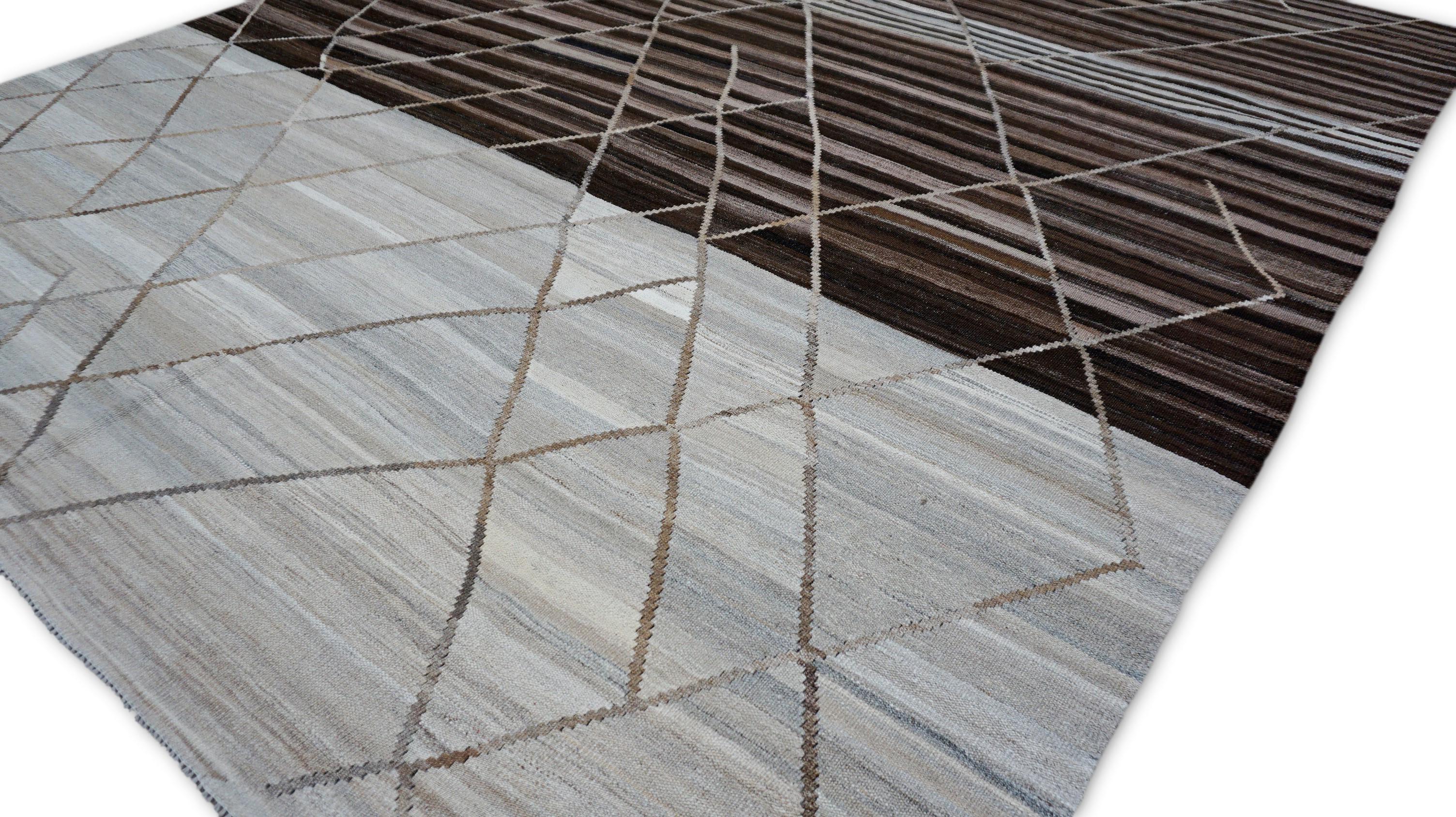 Questo straordinario pezzo è un tappeto in lana kilim tessuto a mano che presenta una composizione grafica audace che fonde la tradizione tribale con il minimalismo moderno. Realizzato a mano con una tecnica di tessitura piatta, il tappeto presenta