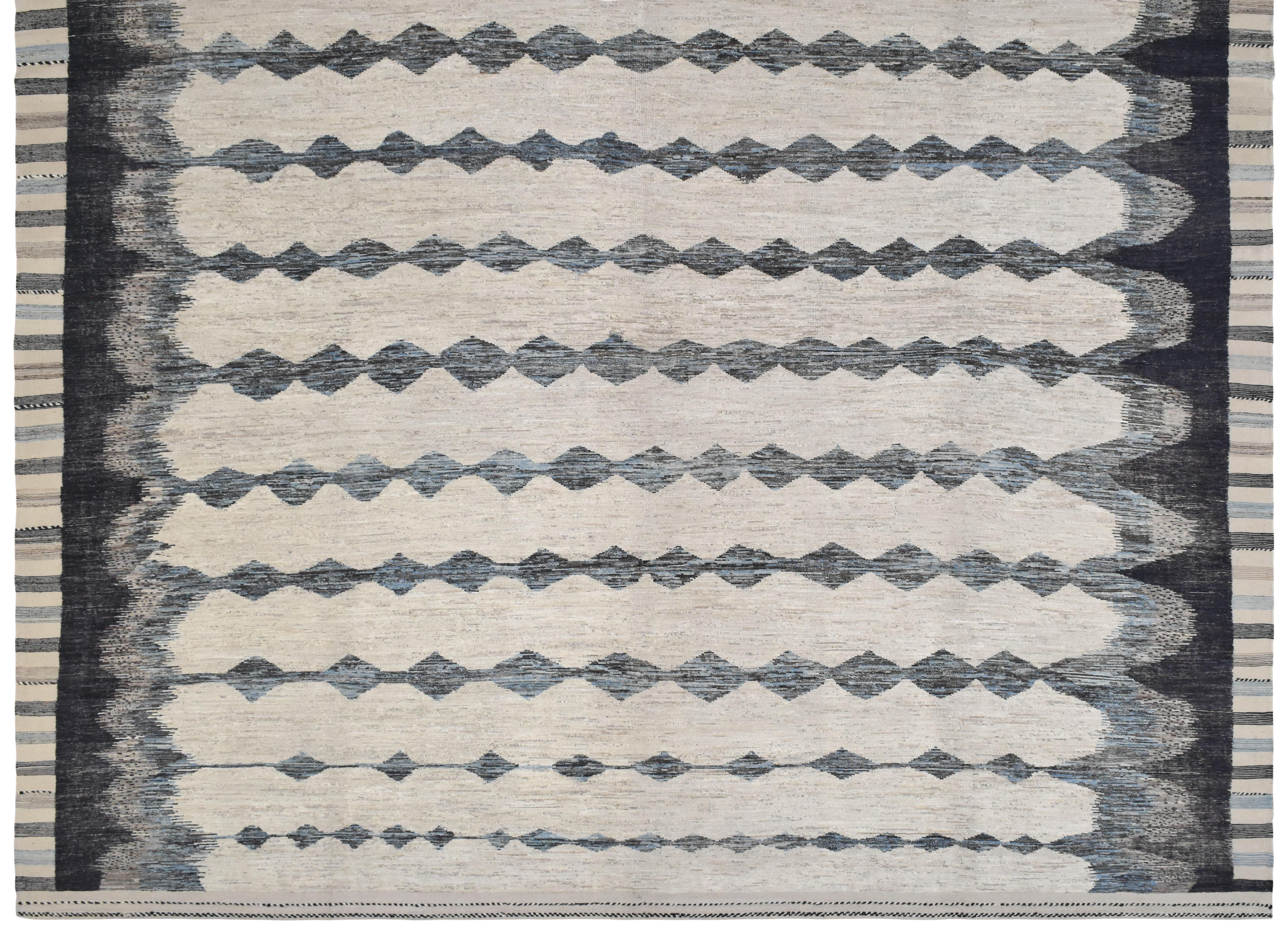 Dieser exquisite handgeknüpfte Wollteppich zeigt eine moderne Interpretation der Stammesästhetik. Das Muster besteht aus sich wiederholenden Rautenmotiven in abwechselnden Blau-, Schwarz-, Elfenbein- und Dunkelbrauntönen, die einen kühnen und doch