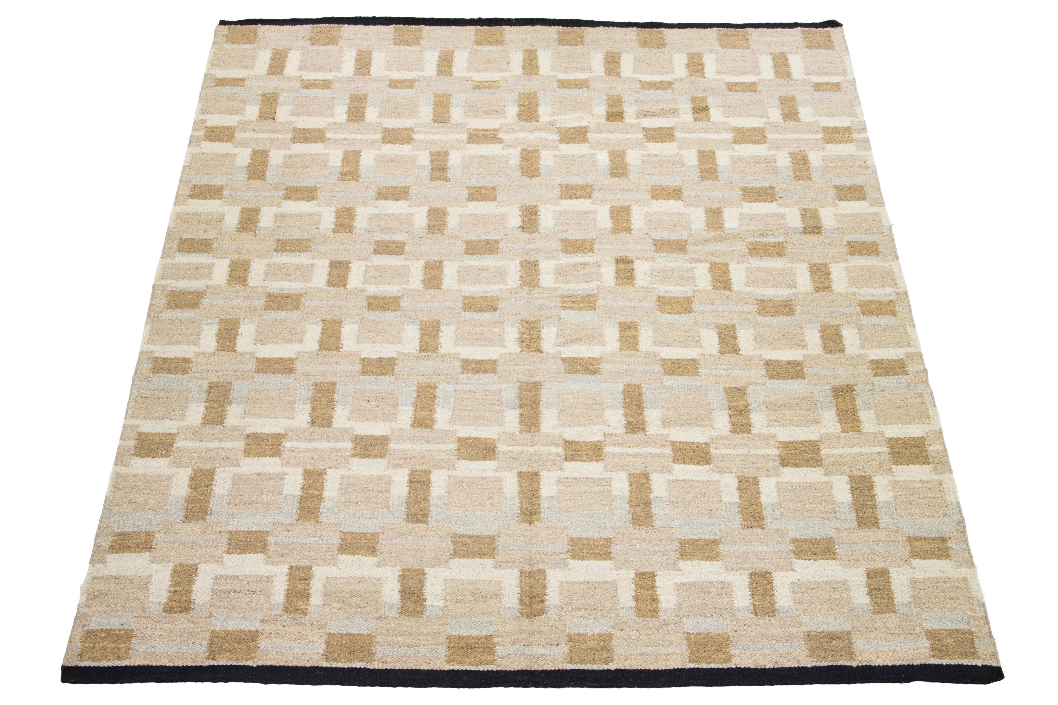 Questo tappeto a tessitura piatta presenta un elegante design Dhurrie contemporaneo con un campo di colore marrone. Il tappeto presenta un motivo geometrico nei toni del marrone, del beige e del grigio.

 Questo tappeto misura 12'4