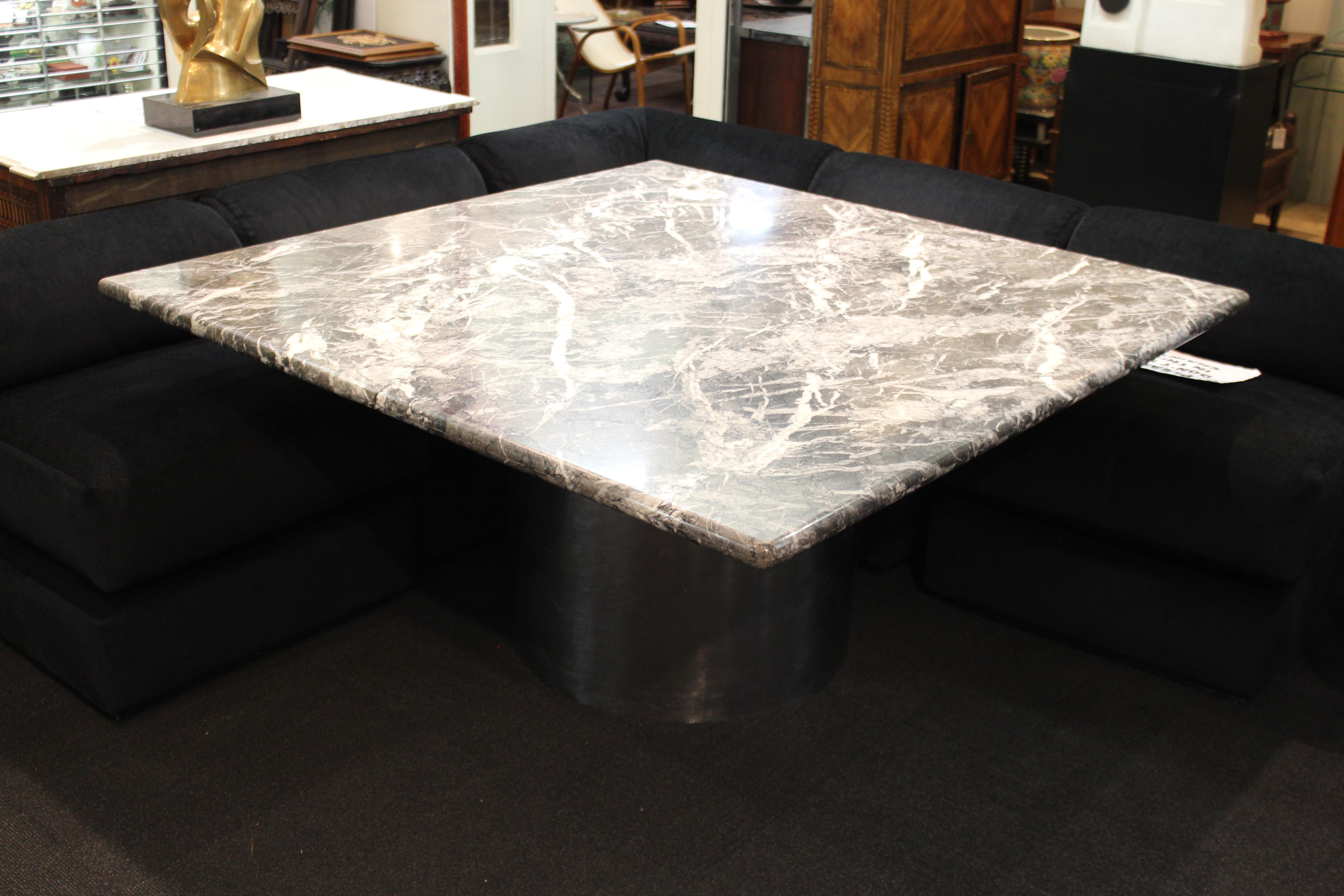 Modern custom made dining table or center table, custom made with a heavy square veined dark marble top on a circular chromed metal base. The piece is in the style of Brueton and was likely custom made during the late 20th century. In great vintage