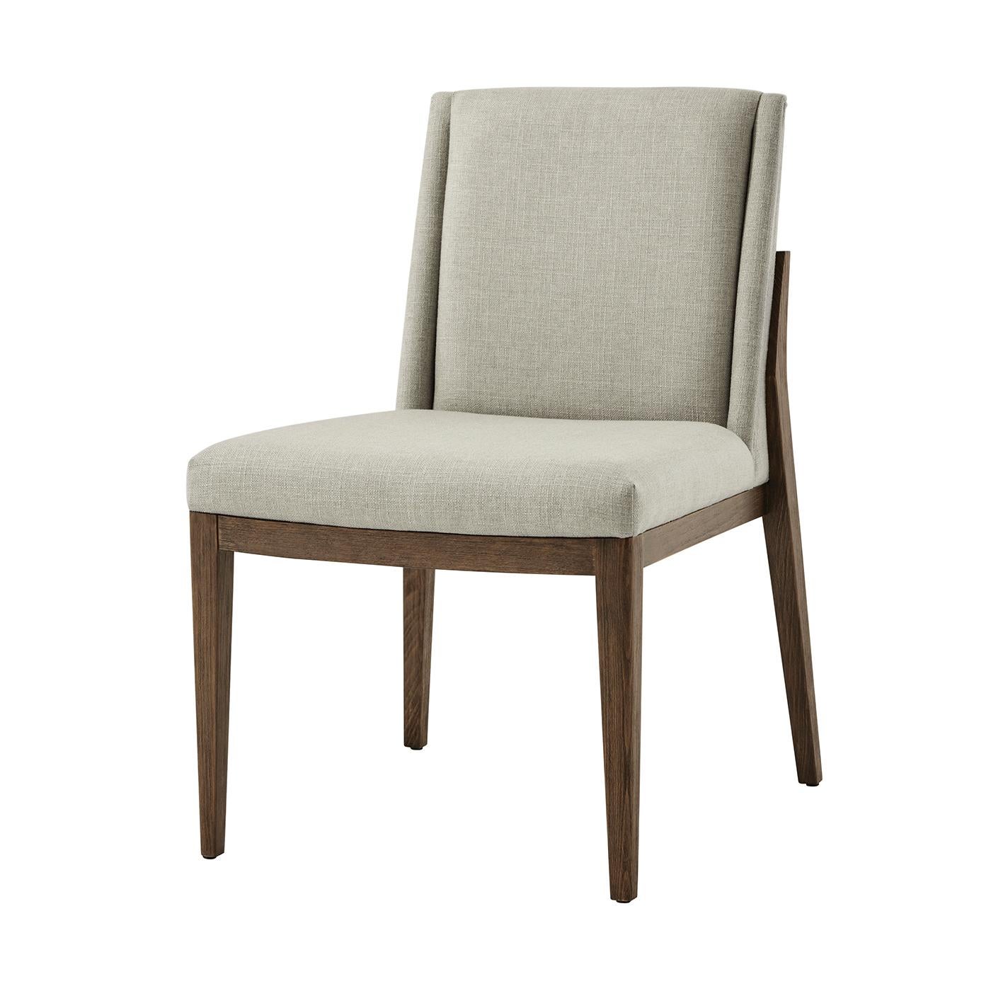 Moderna sedia da pranzo imbottita, in legno di faggio spazzolato e rifinita con la nostra finitura charteris, con schienale imbottito e seduta ad arco. Si erge su gambe quadrate affusolate e svasate. Il rivestimento è in tessuto performante e