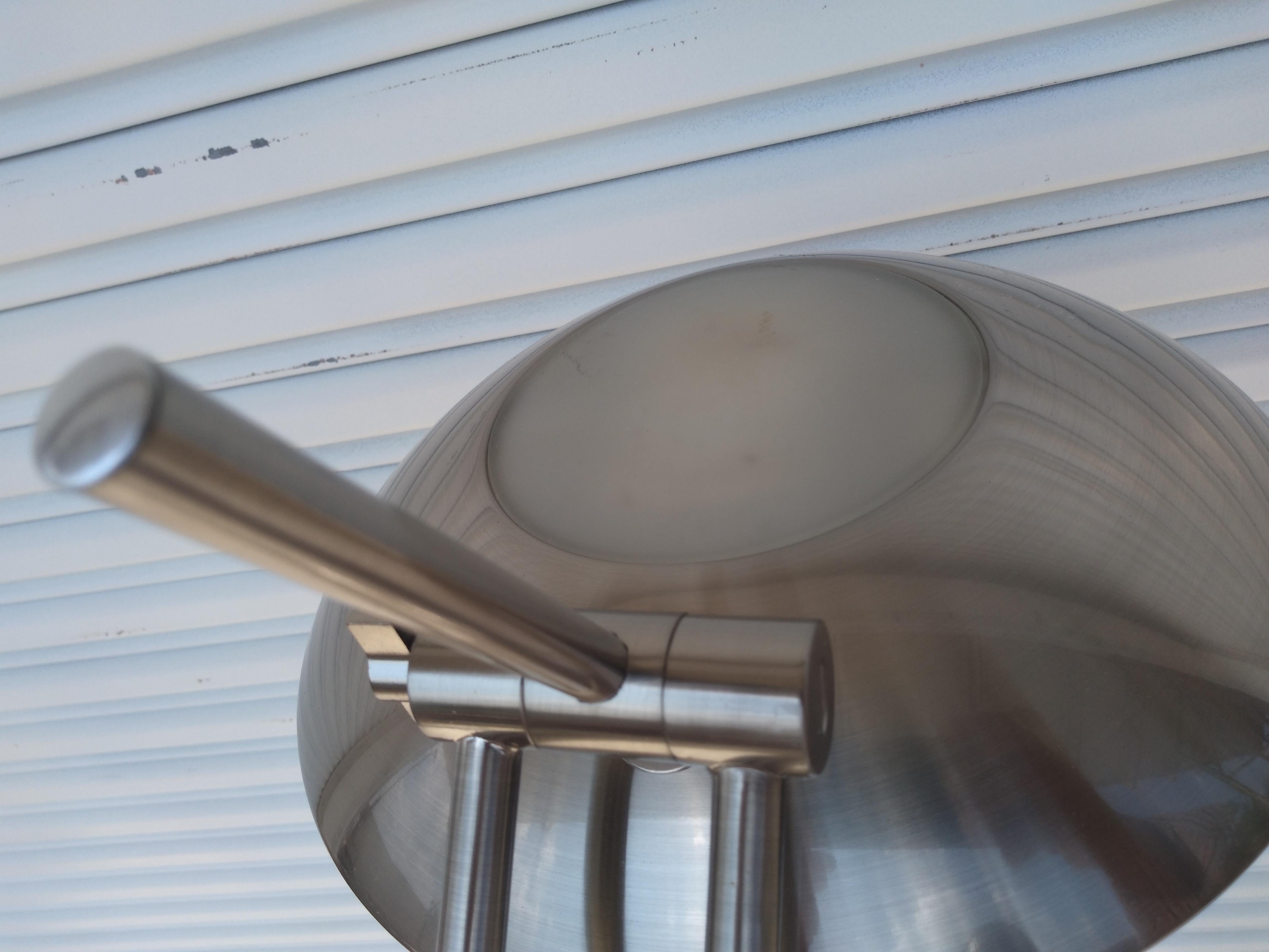 This is a brushed nickel floor lamp. The height is adjustable and swivels. The base is weighted for added stability. It has a foot controlled dimmer switch.