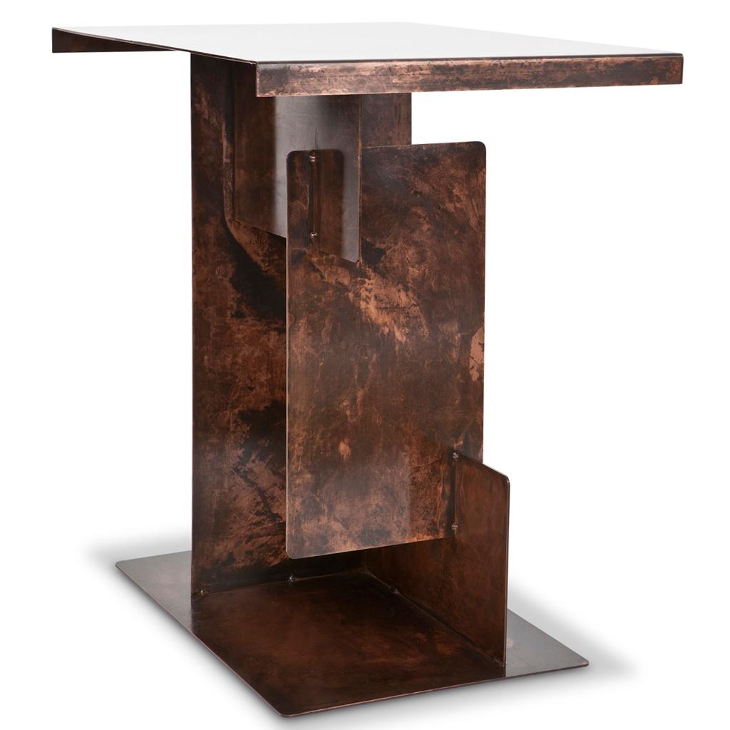 The Puzzle Side Table is monumental in attitude — its steel-plated form constructed as if from interlocking segments. Available in antique copper or Antique brass finishes, its geometry recalls Brutalist architecture and sculptural furniture from