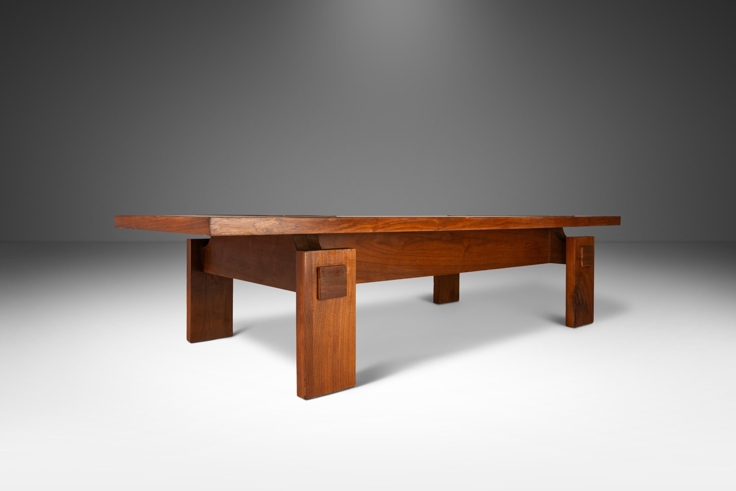 Introducing a stunning piece of vintage furniture that is sure to elevate any living space. This late 1970's Lane Furniture Brutalist coffee table is constructed from beautiful American black walnut wood, featuring a long, rectangular design with