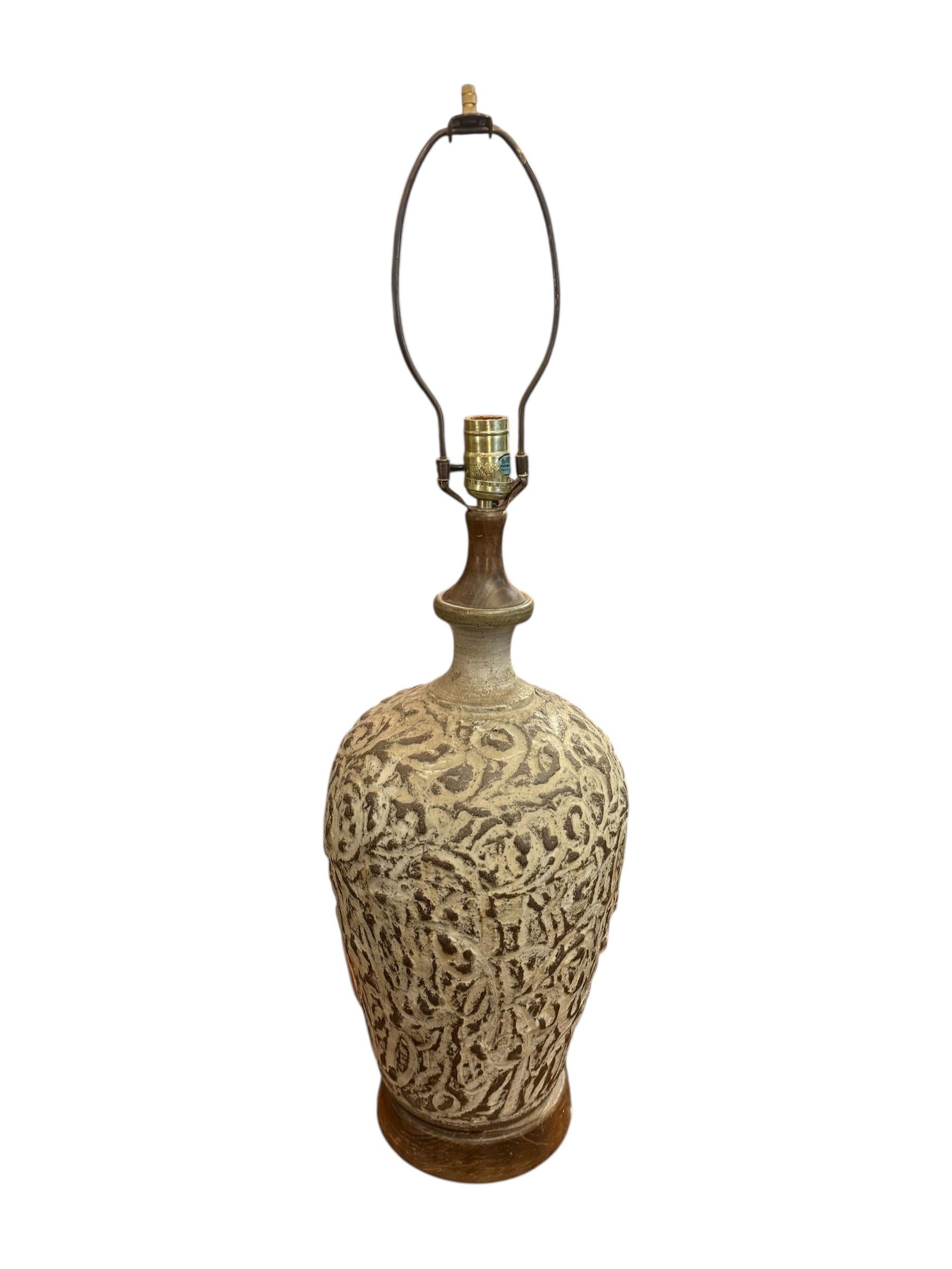 Élevez votre décor avec cette étonnante lampe de table moderne brutaliste en argile, une fusion de texture brute et de forme sculpturale. La base en argile moulée à la main présente un motif organique en relief dans des tons crème et taupe, évoquant