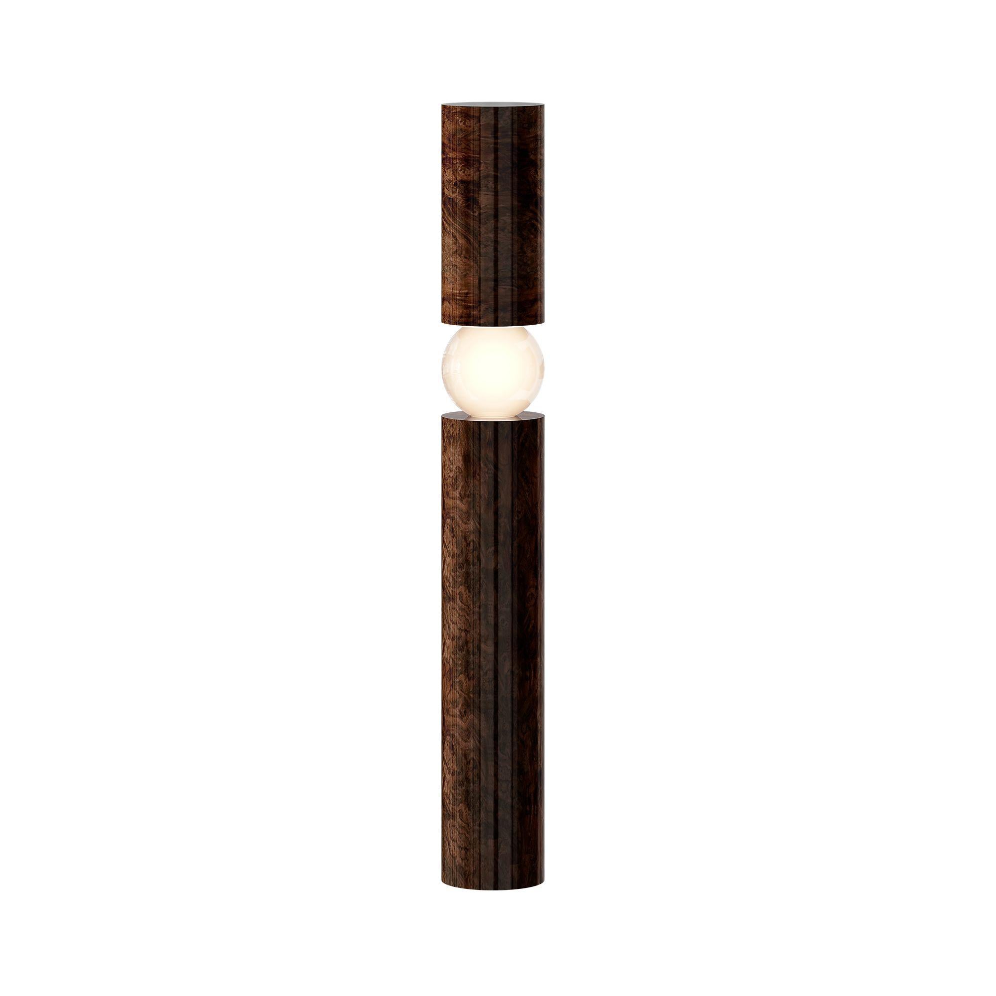 The Orpheu Floor Lamp Wood redefines design, featuring a sleek cylindrical wood structure that frames a floating light source at its core. Crafted with a wood base, it balances warm natural textures with a brutalist aesthetic. The suspended