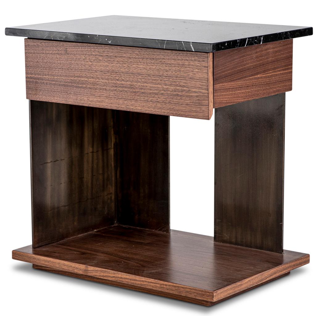 The Puzzle bedside table is a combination of solid & veneer walnut timber with Nero Marquina black marble top. The top & drawer are set on bronzed steel legs. This bedside pedestal has a distinct modern & mid-century modern appeal. This bedside