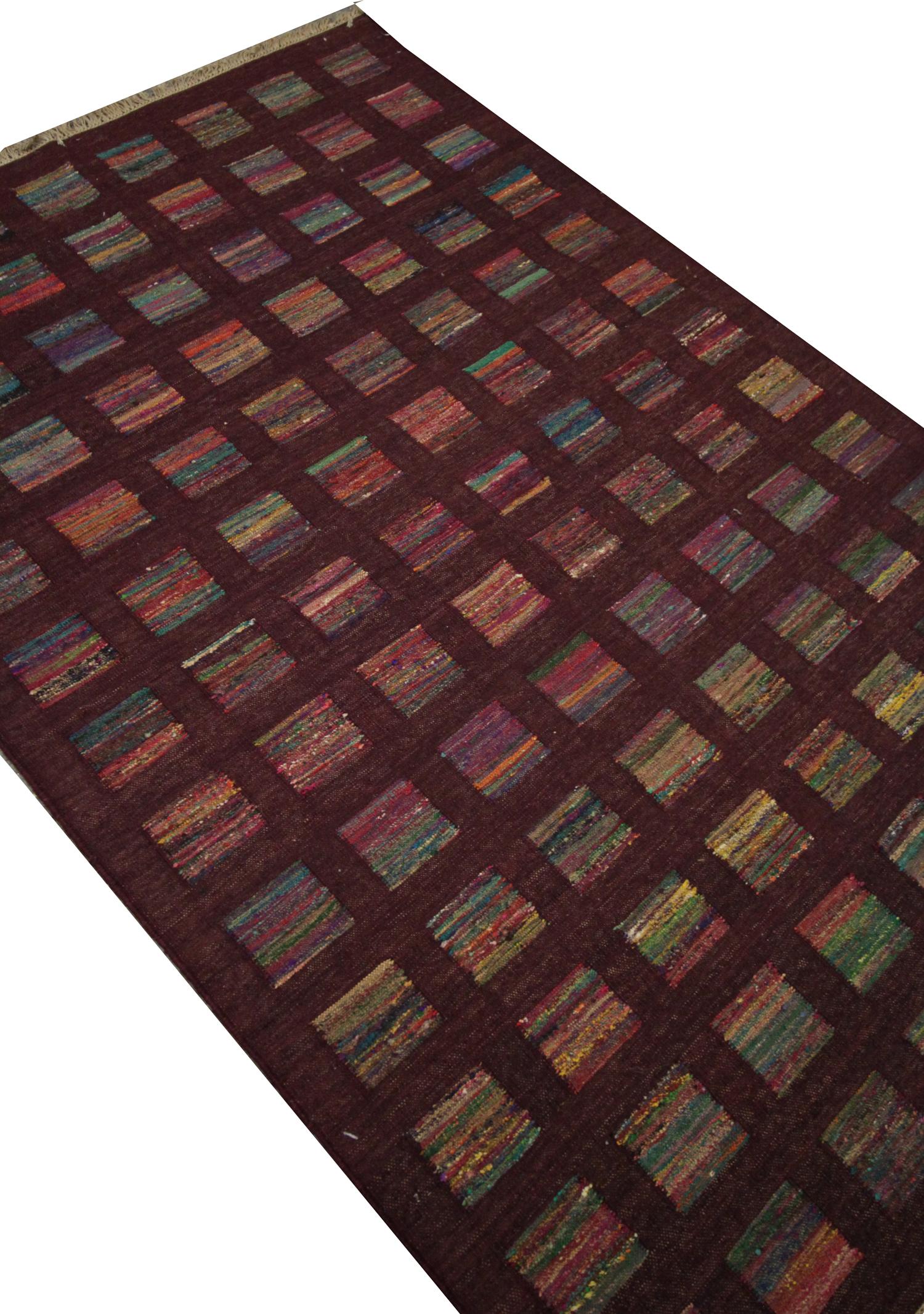 This piece is an excellent example of modern Kilims woven by hand in India. This piece was constructed in the early 2000s and is in excellent condition, having never been used. The design features a burgundy background with a grid of squares that