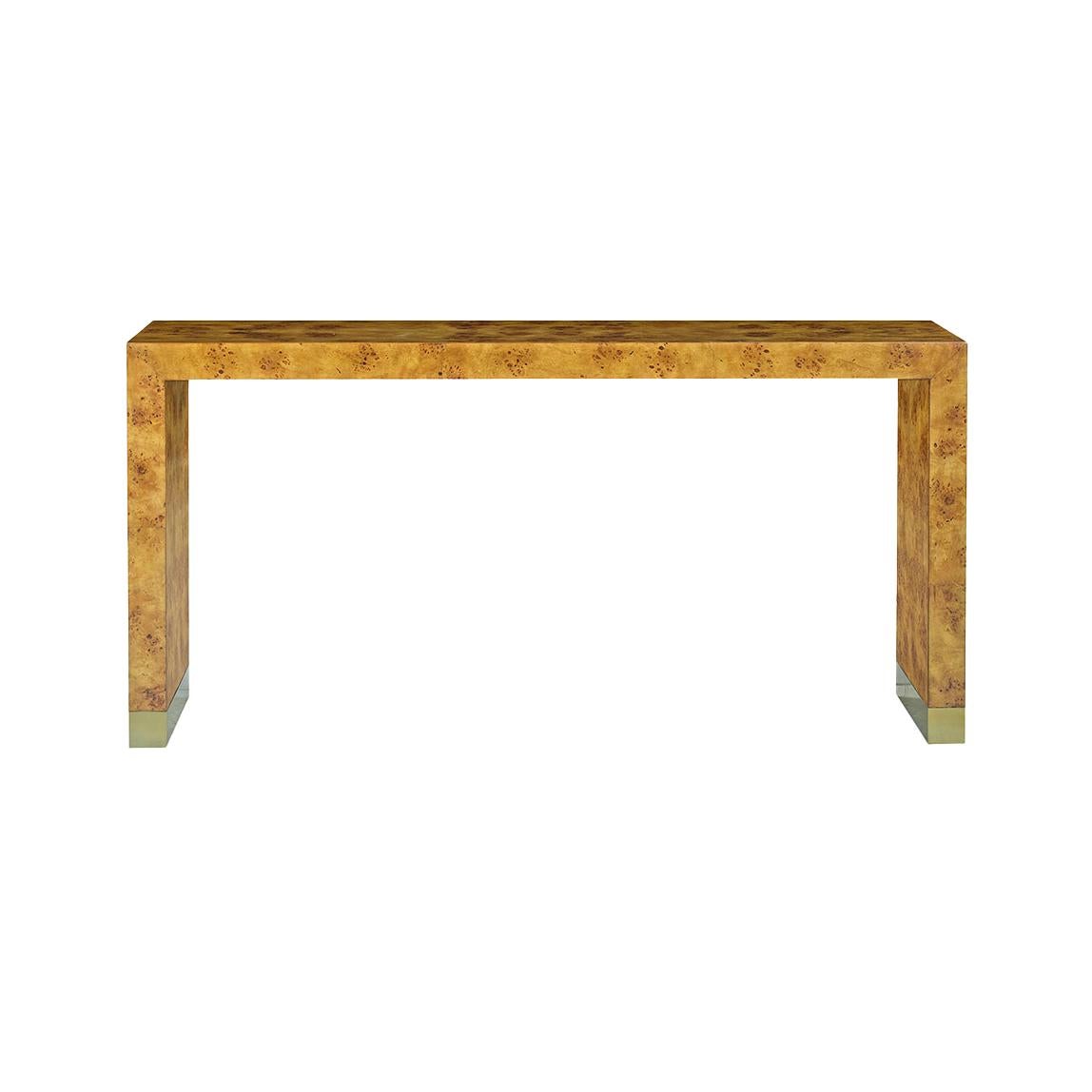 Crafted from premium mappa burl wood veneer, this table features clean, geometric lines that highlight the natural golden tones and intricate grain patterns of the wood. The brass-capped feet add a touch of contemporary elegance, making it a