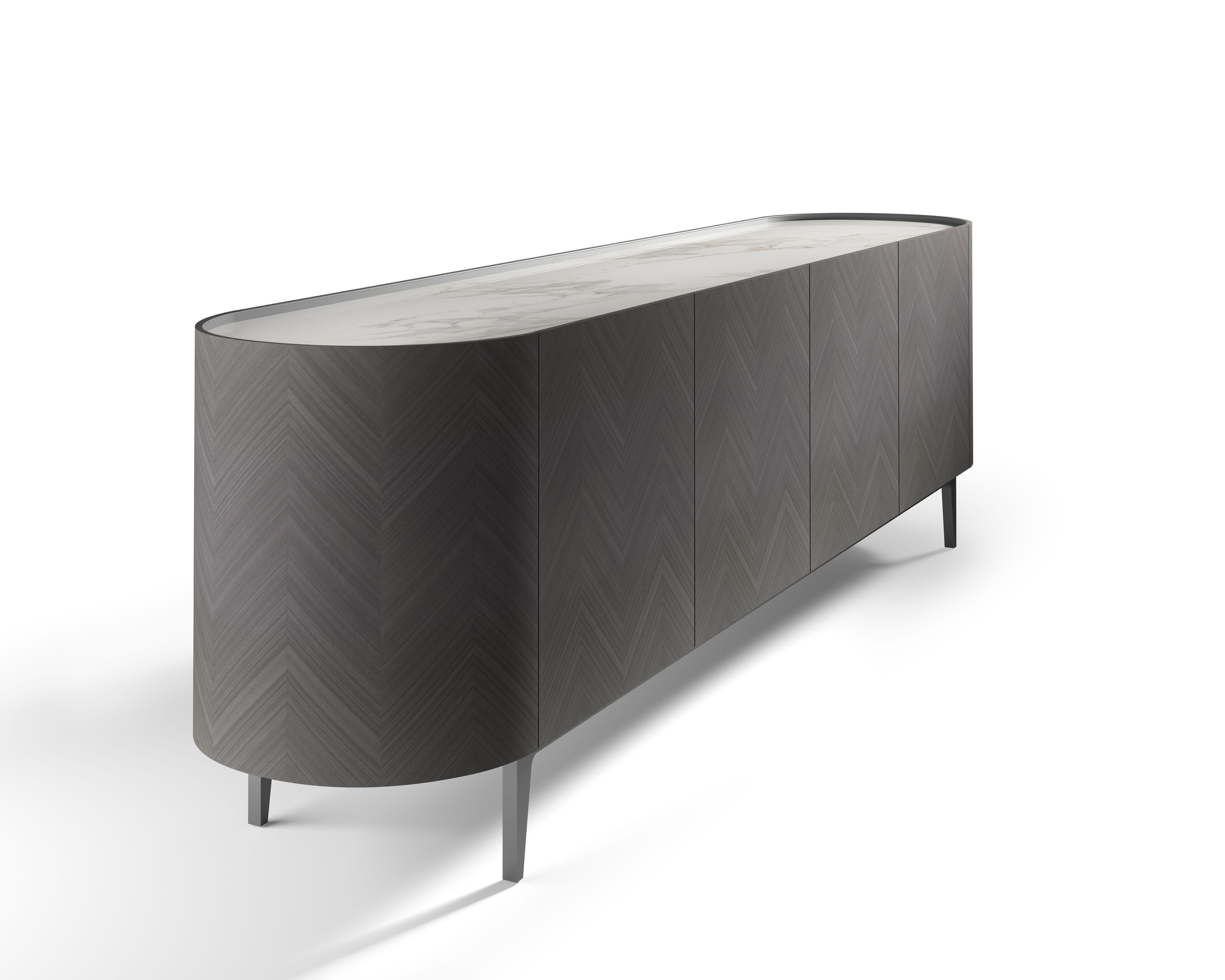 This is a sideboard with a clean line, covering with geometric inlay in precious wood. It is available in light Tay, Dark Tay and Canaletto Walnut. Top with storage unit available in Painted Glass, Marble and Wood. Top profile and chest of drawers