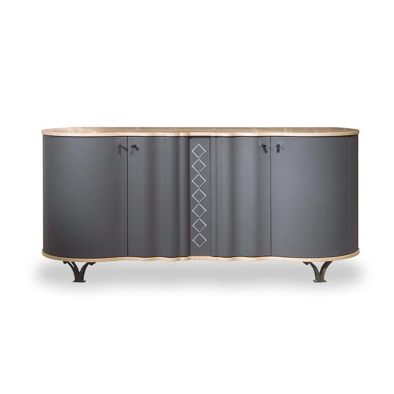 Sideboard characterised by the soft curvilinear shape. The doors and sides can be covered in different materials such as leather, nabuk, faux leather or faux nabuk. In the center of the front there is an embroidered geometric decoration.
The
