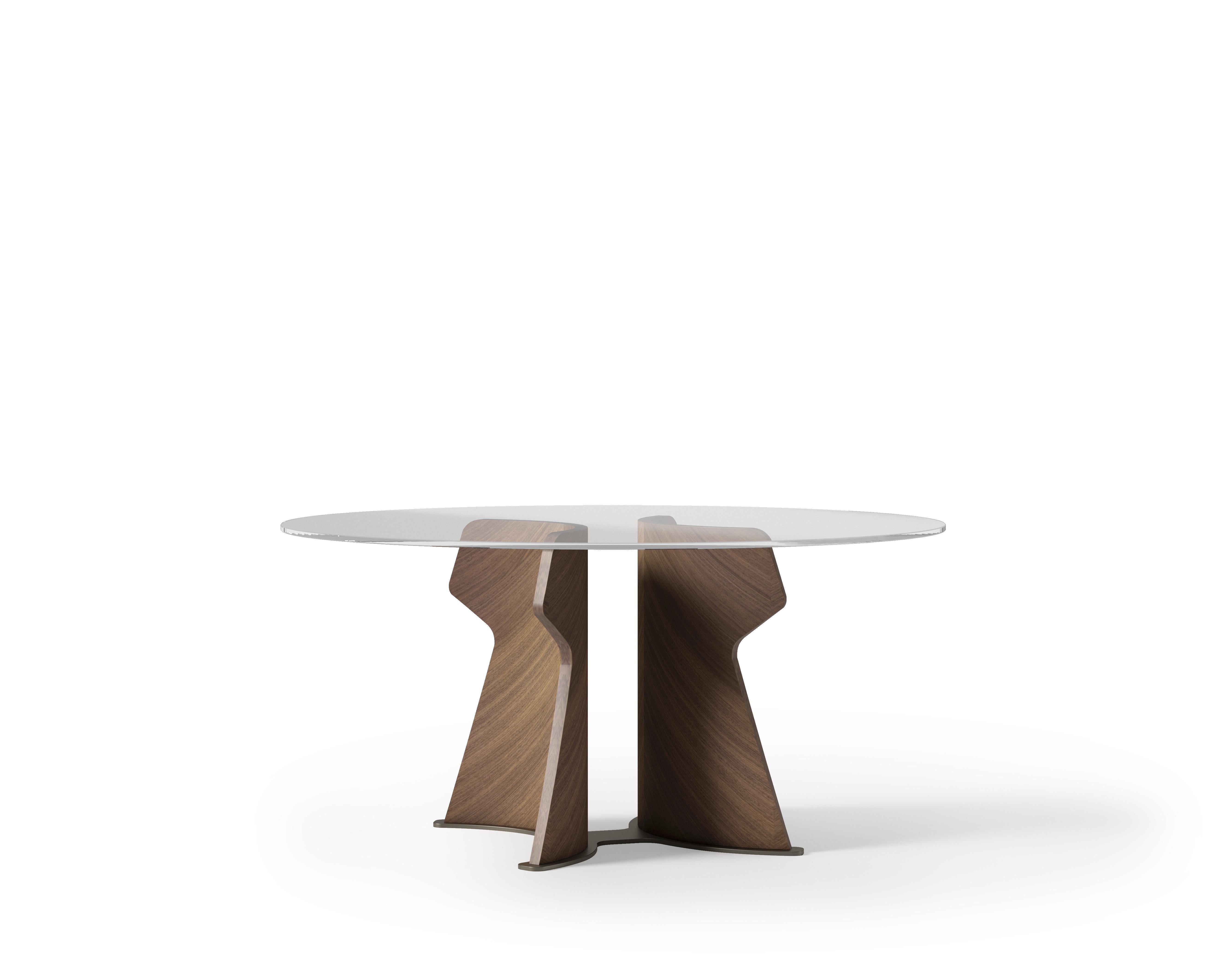 Table inspired by the decisive features of the architecture of Easter Island. It is characterized by a sculptural base covered in precious woods, available in light Tay, dark Tay and in Canaletto Walnut. The top is round or oval in extra-clear