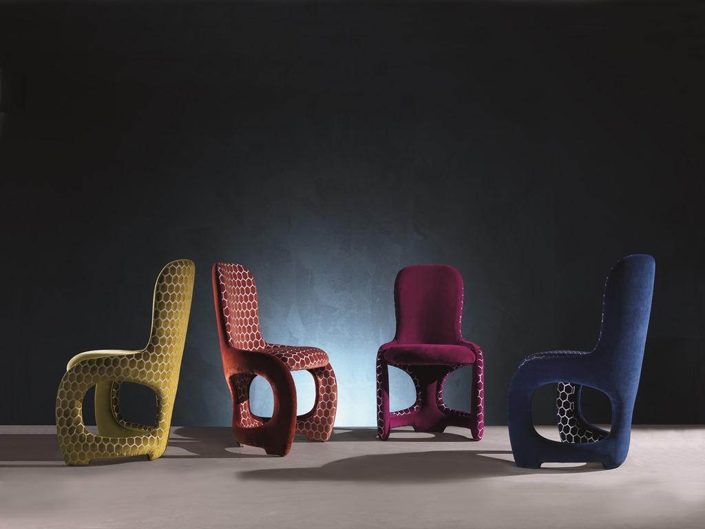 Chair with curved structure and back. The curvy lines create an enveloping and comfortable seat. The upholstery can be realized with fabric or leather.