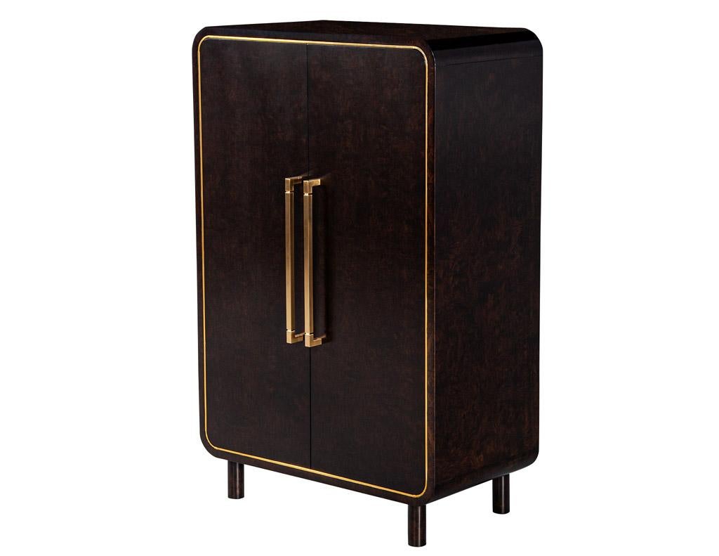 This modern cabinet is the perfect addition to any home. Crafted from burl walnut wood with brass metal inlay and large brass handles, it is finished in a dark espresso satin color for an elegant yet modern look. Its curved modern design is inspired